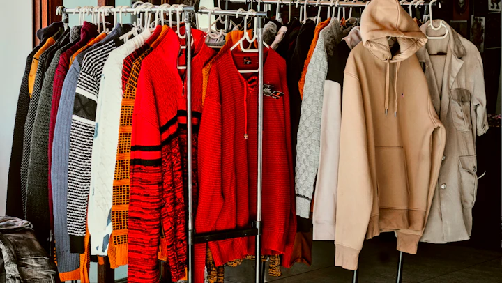 A rack of clothes in a closet with clothes hanging on it