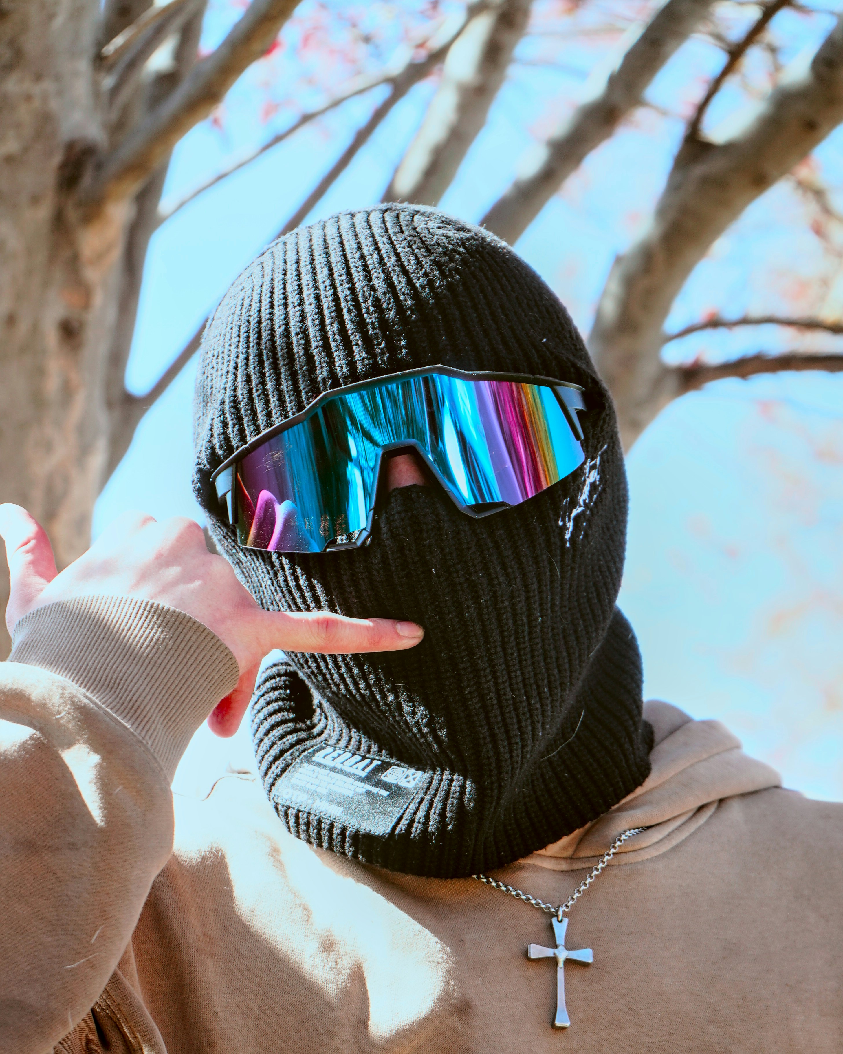 A person wearing a black ski mask and sunglasses