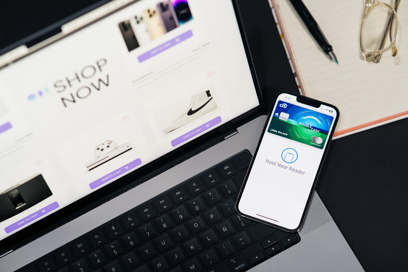 A clean online storefront on a laptop beside a phone completing a tap-to-pay checkout