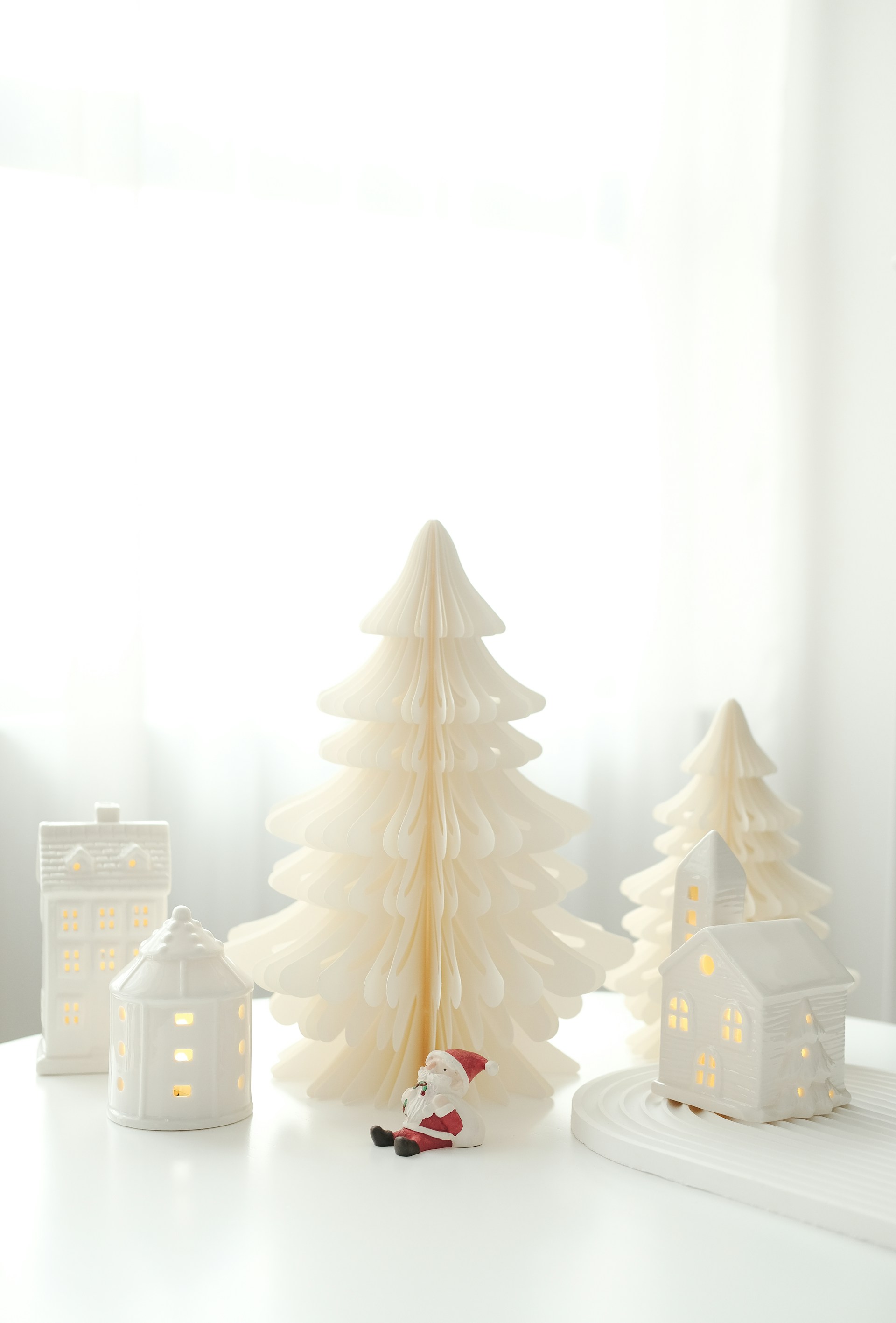 A white table topped with white christmas trees