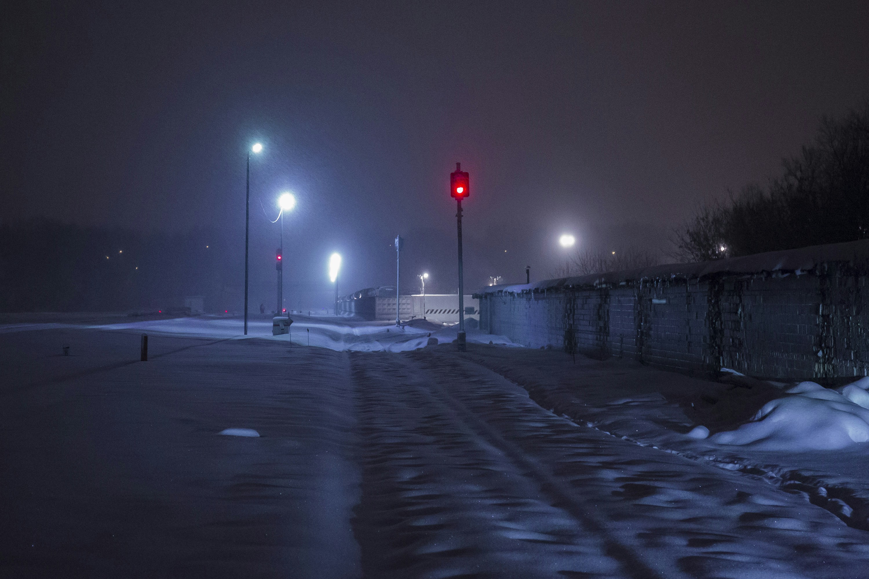 A red traffic light sitting on the side of a road