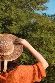A woman in an orange dress and a brown hat