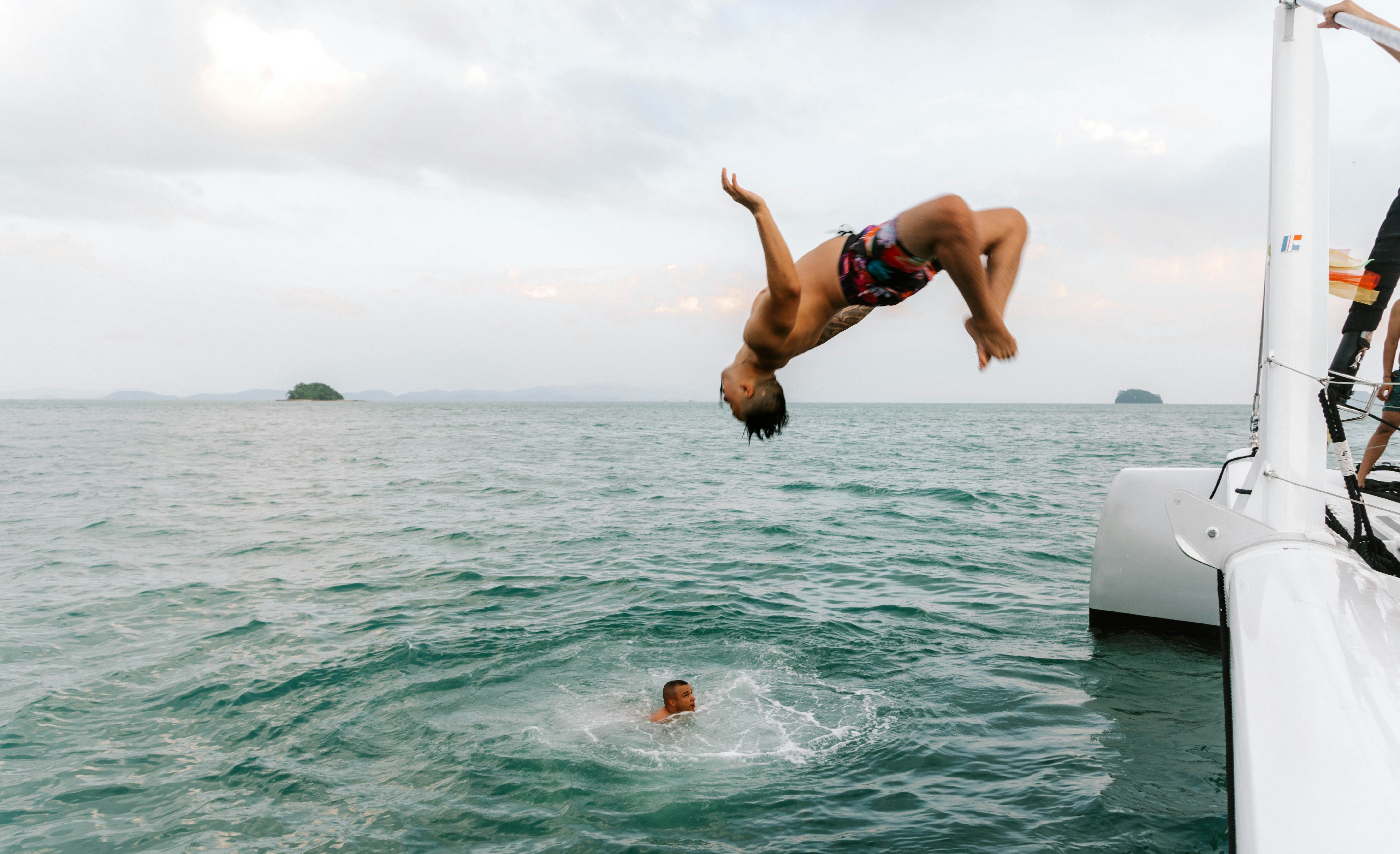 A man diving into the ocean from a boat