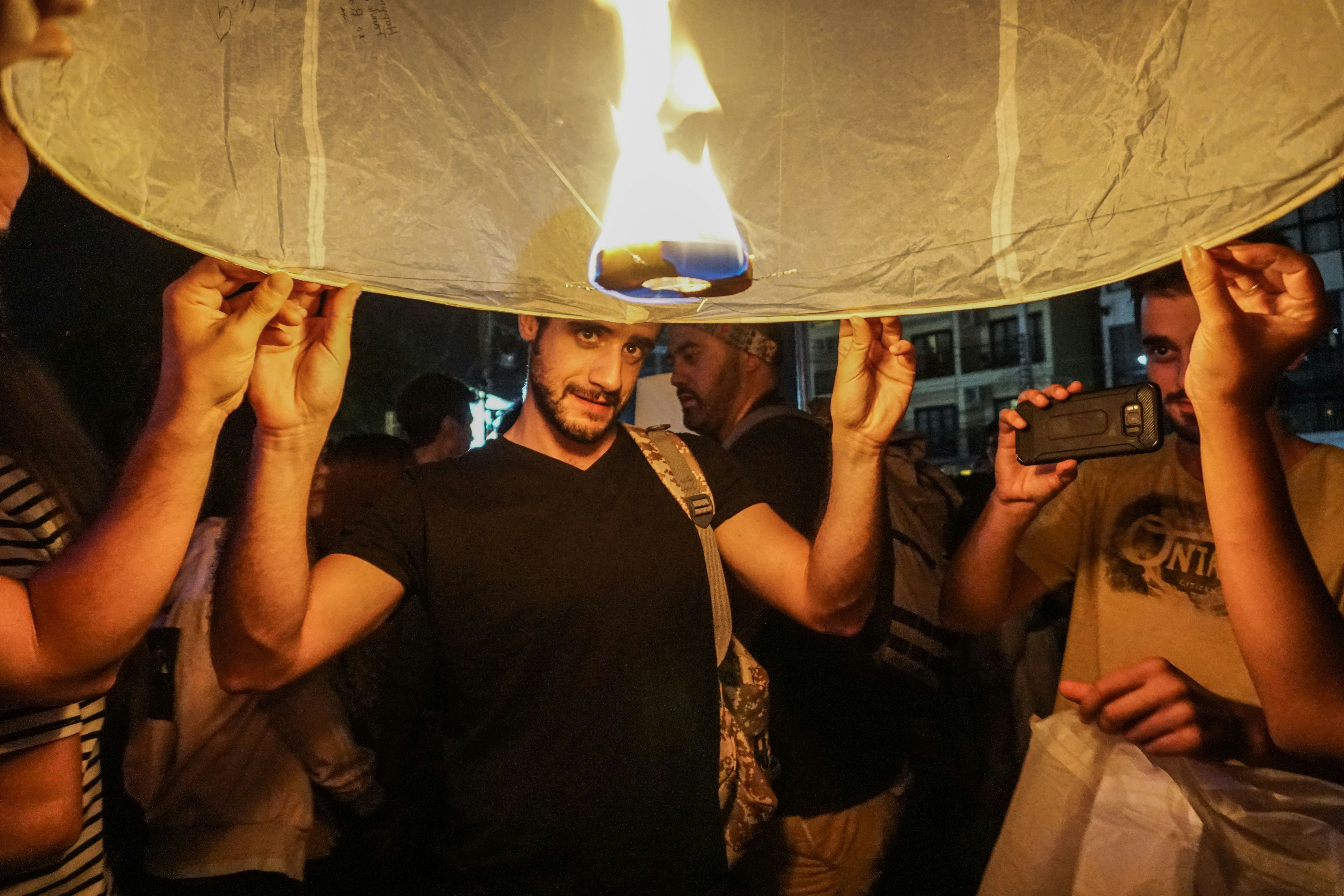 A group of people standing around a fire pit
