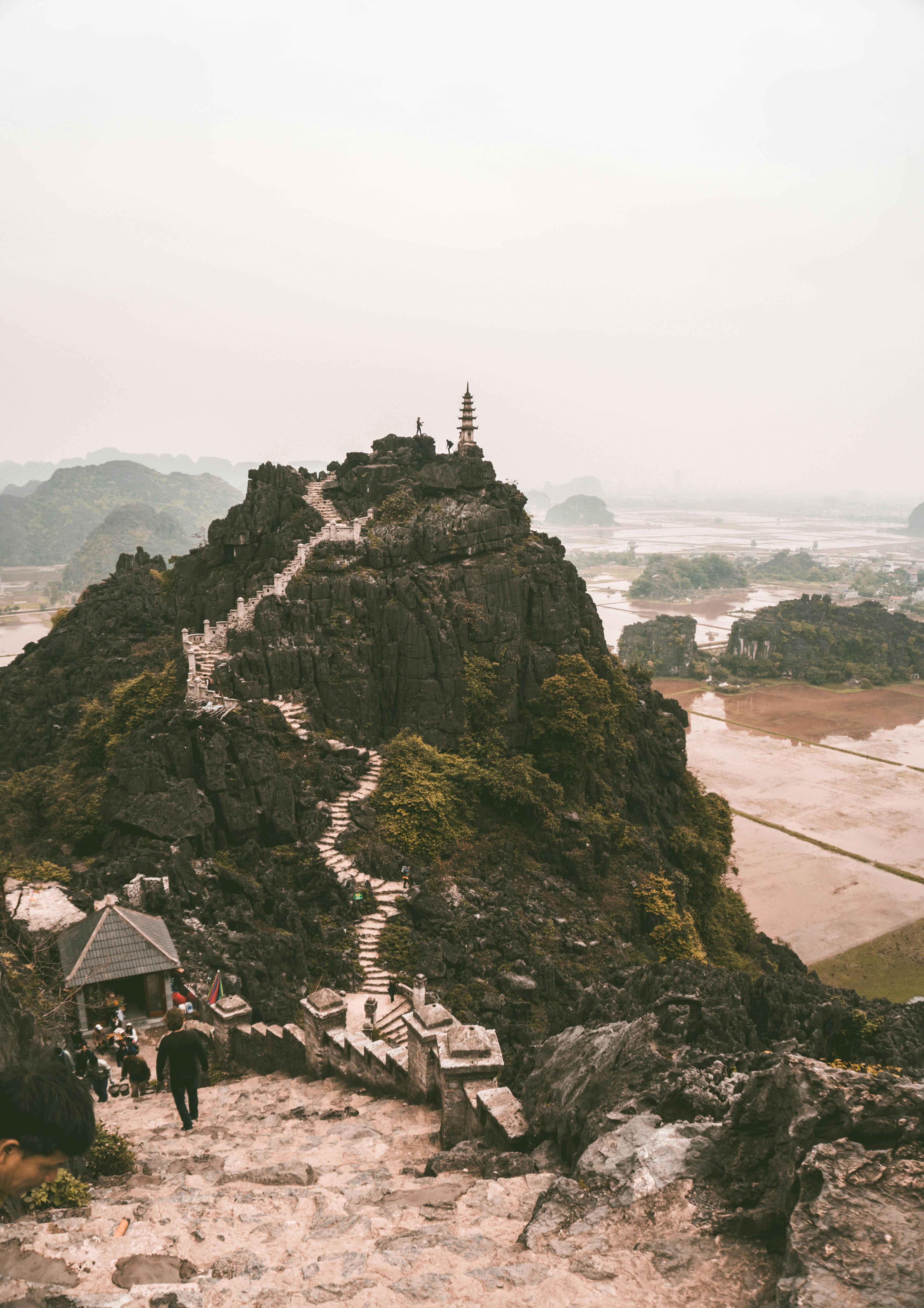 A rocky mountain with a pagoda on top of it