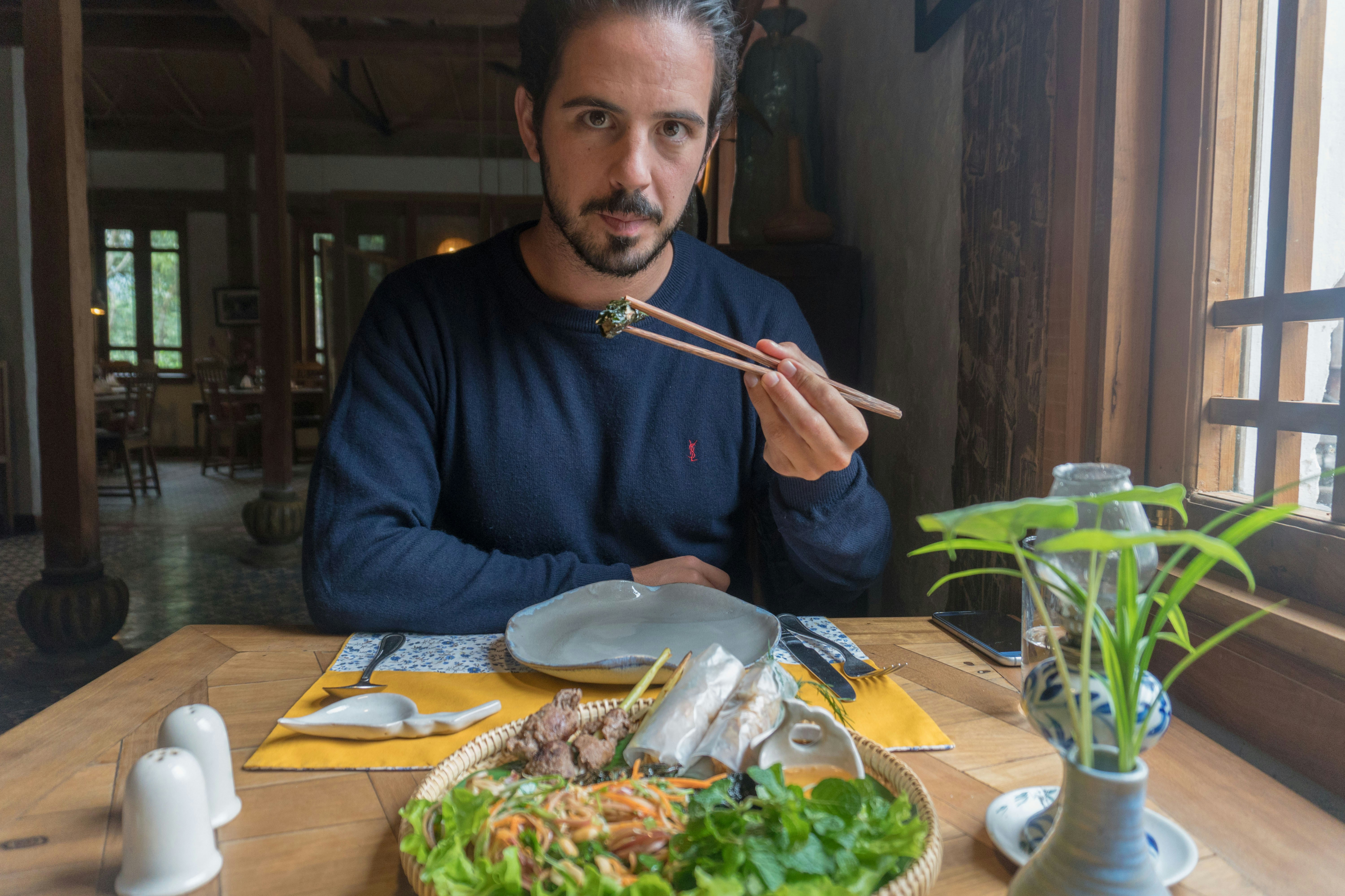 A man sitting at a table with a plate of food