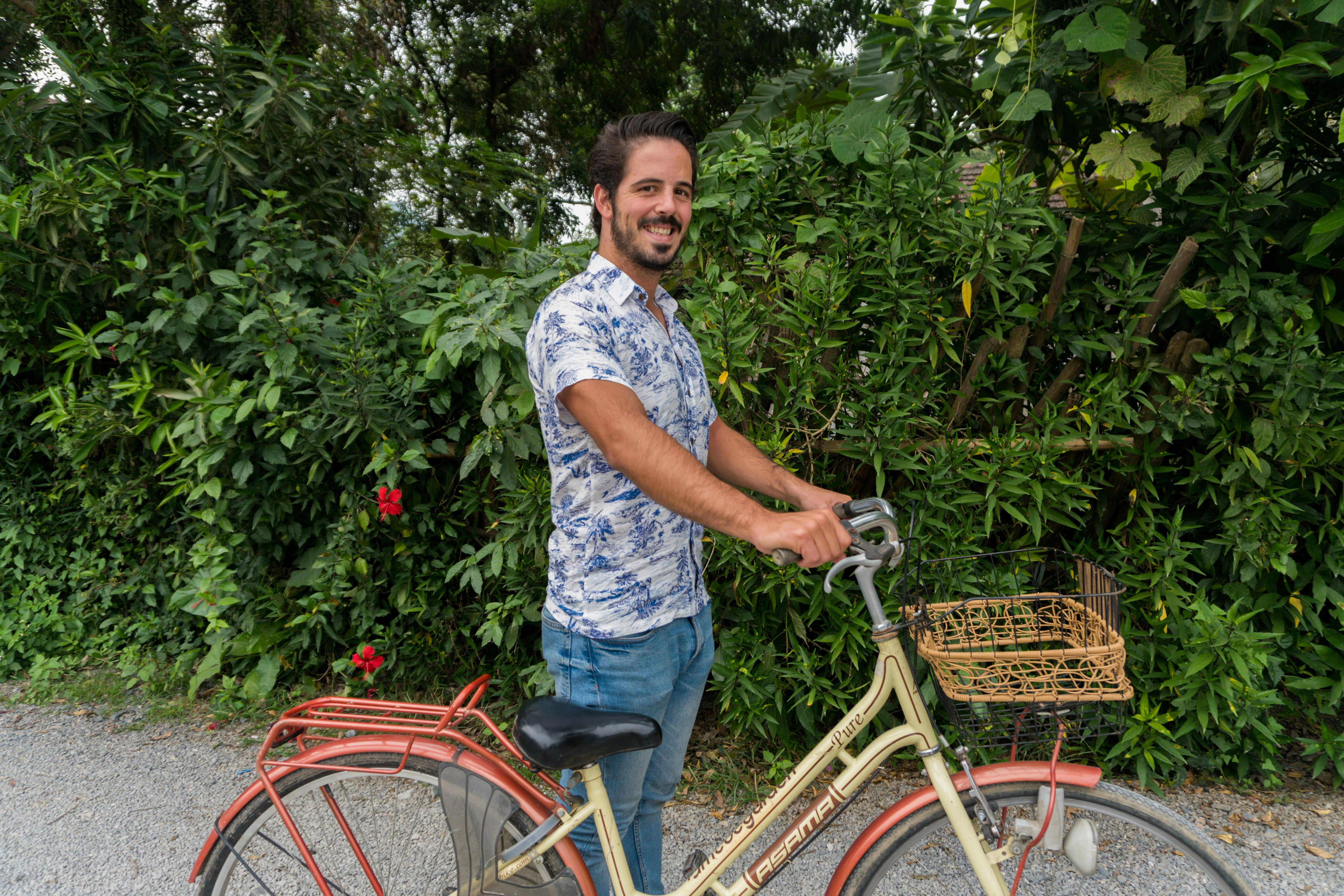 A man standing next to a yellow bicycle