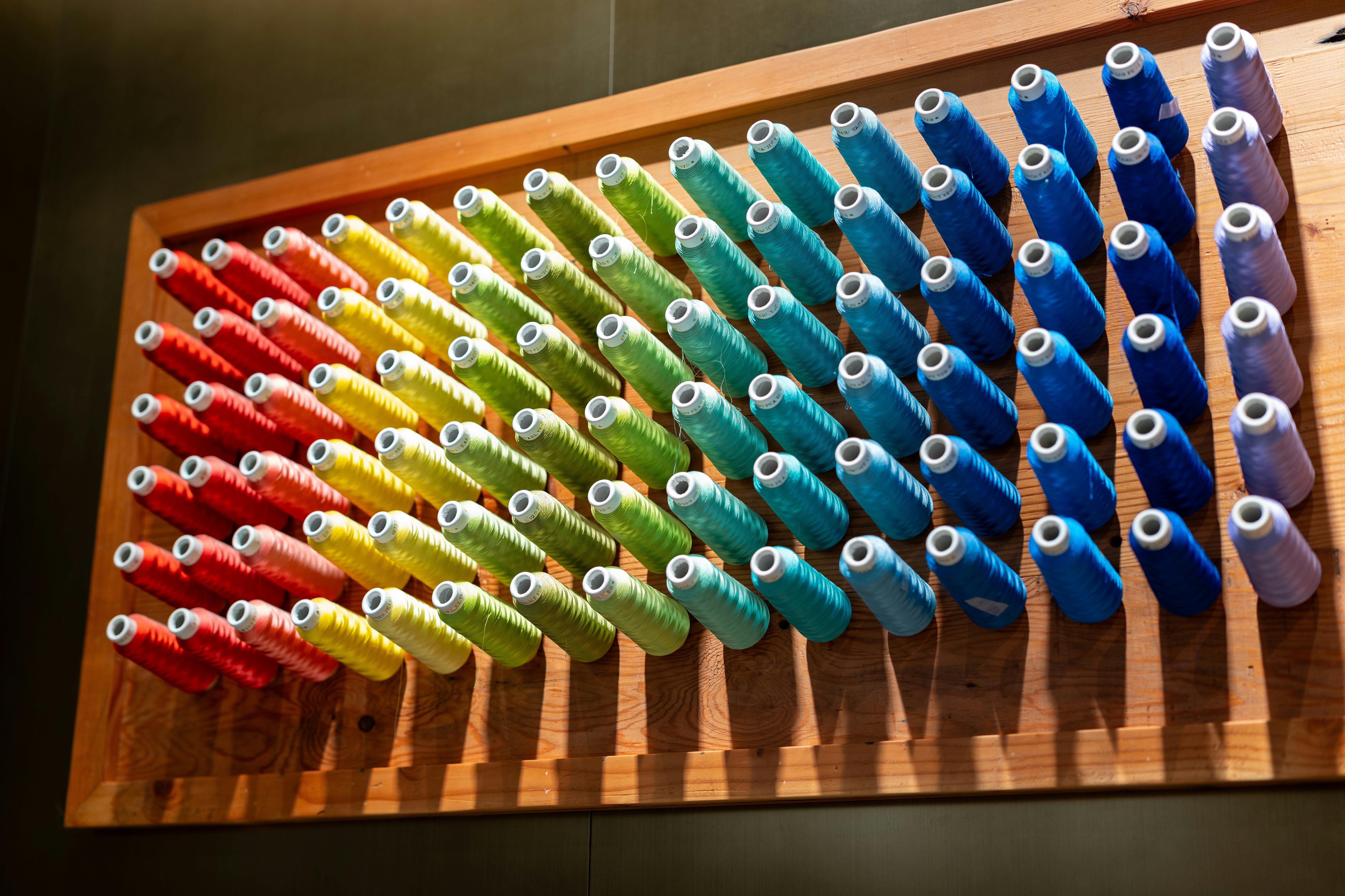 A wooden rack filled with lots of colorful toothbrushes