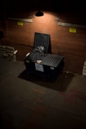 A dark room with a chair and a brick wall