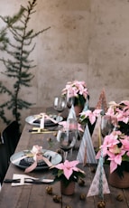A wooden table topped with lots of pink flowers