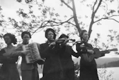 Five women playing musical instruments outdoors