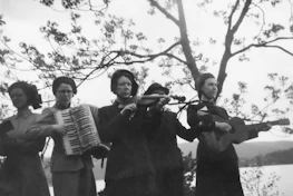 Five women playing musical instruments outdoors