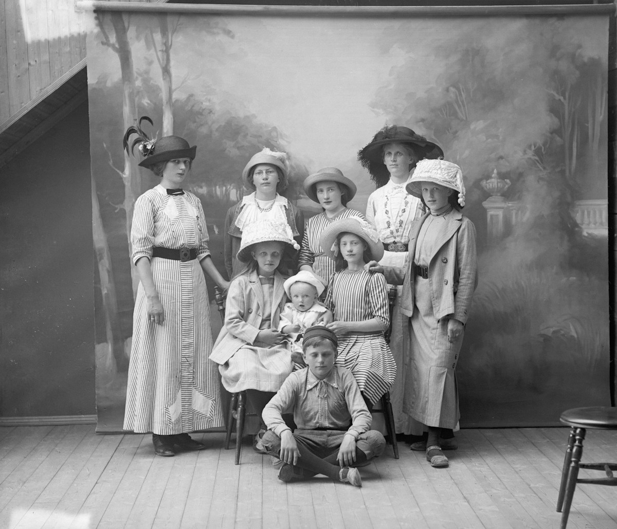 A family of seven, including children in scout uniforms, poses for a studio portrait.