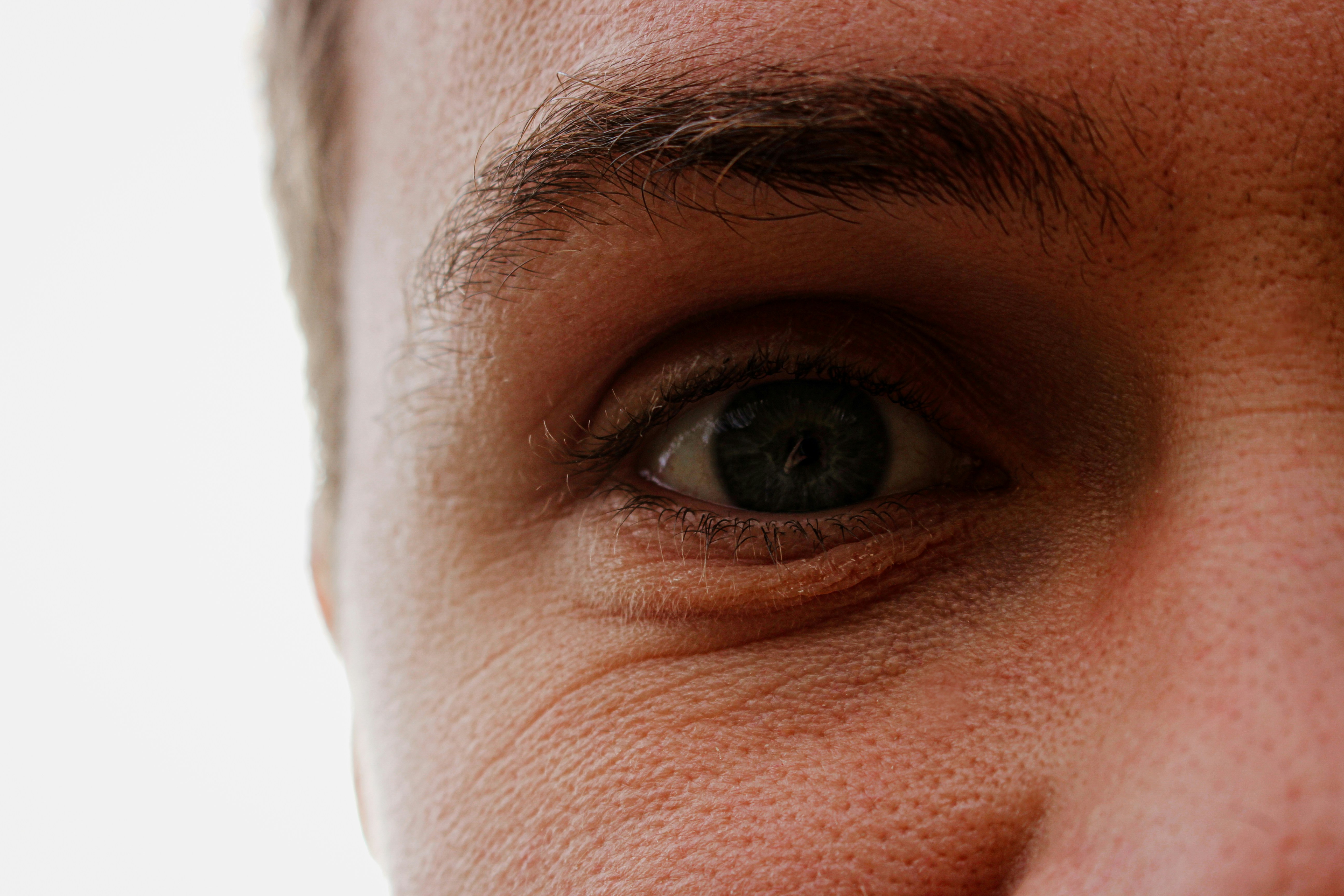 A close up of a man's face with a toothbrush in his mouth