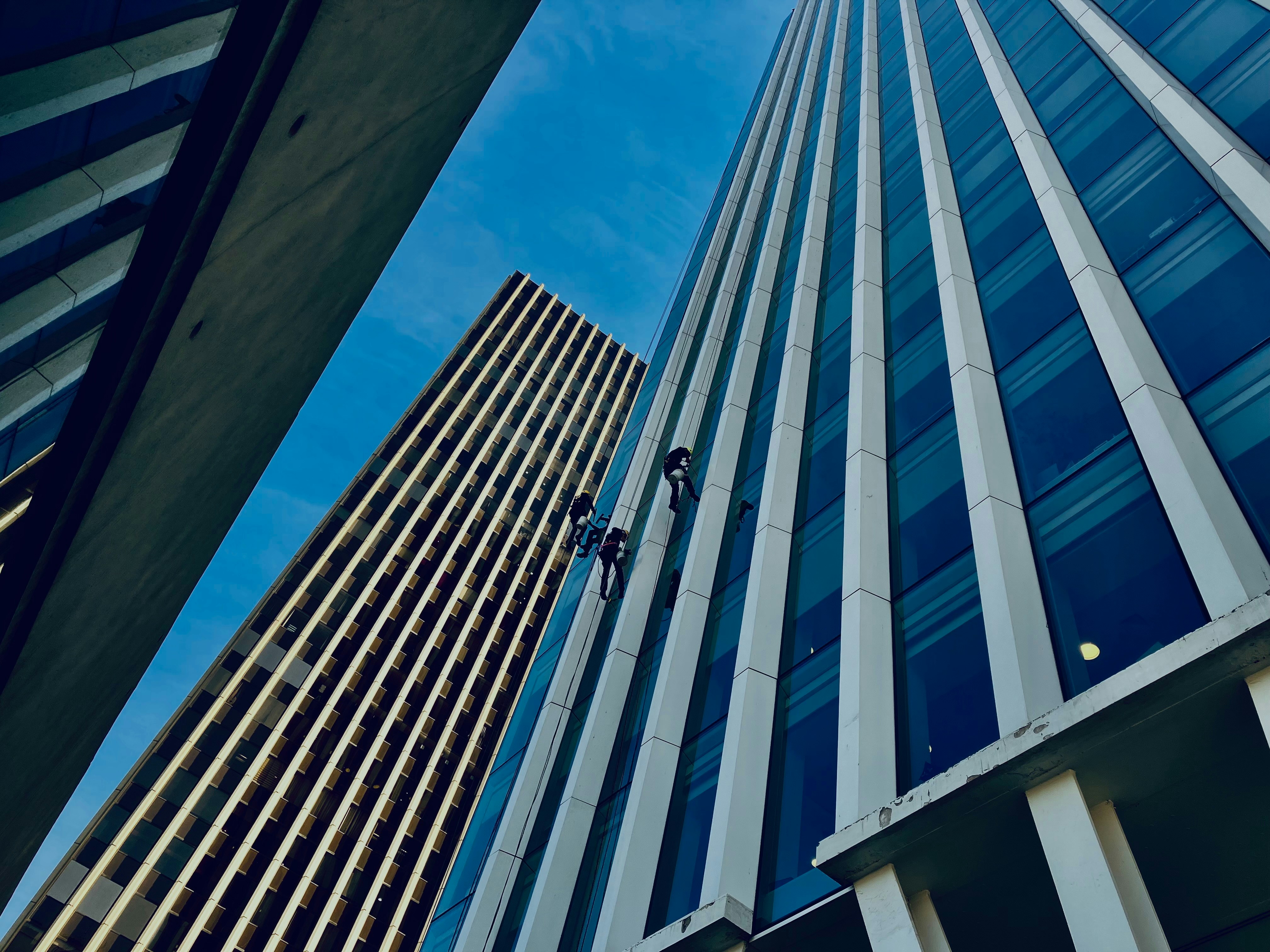 Dev bir şirketin modern giriş kapısının önünde duran, başarıyı ve yeni fırsatları hedefleyen özgüvenli profesyonel bir iş insanı.