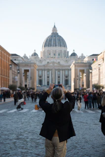 A woman taking a picture of a large building