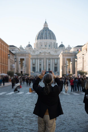A woman taking a picture of a large building