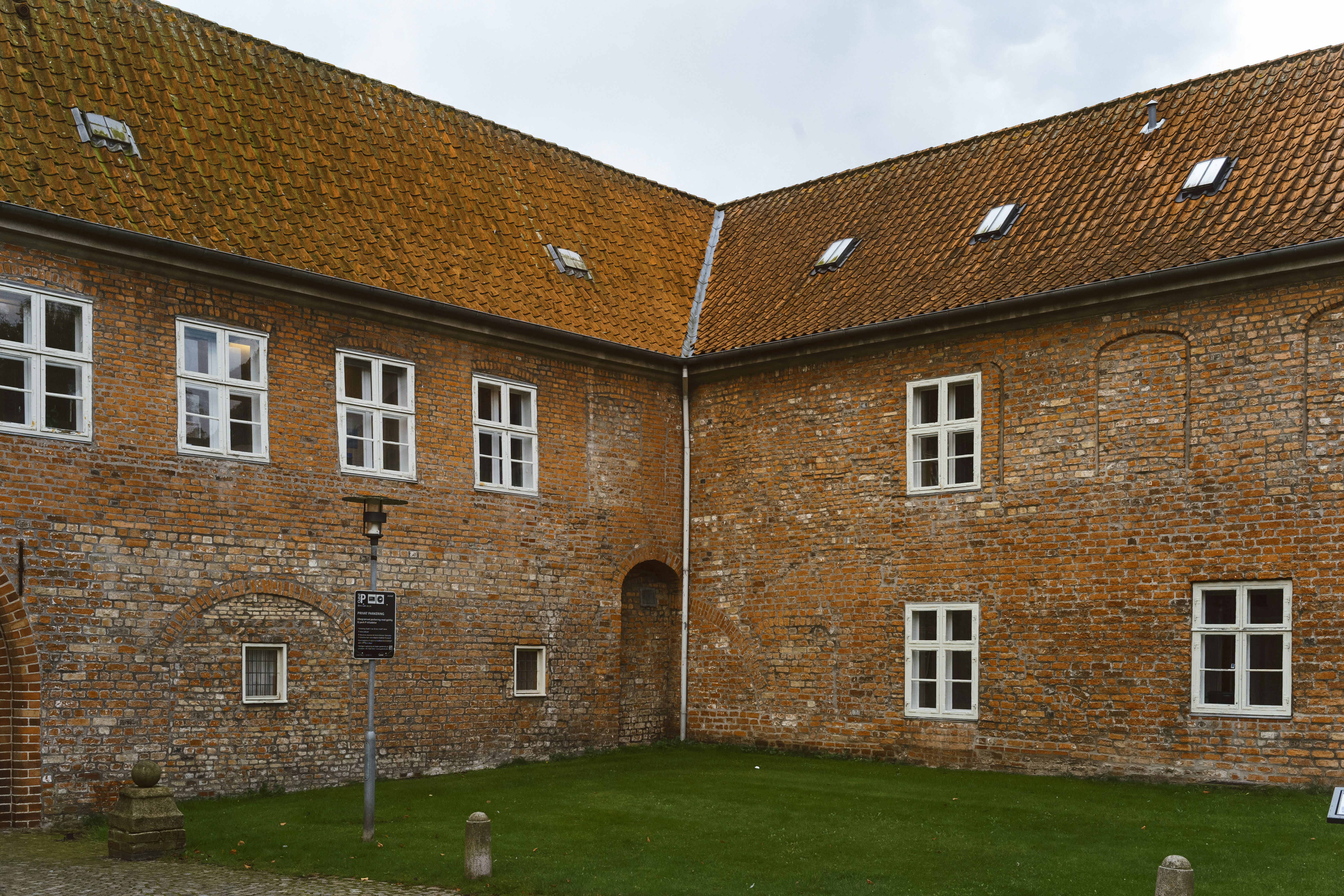 A large brick building with a lawn in front of it