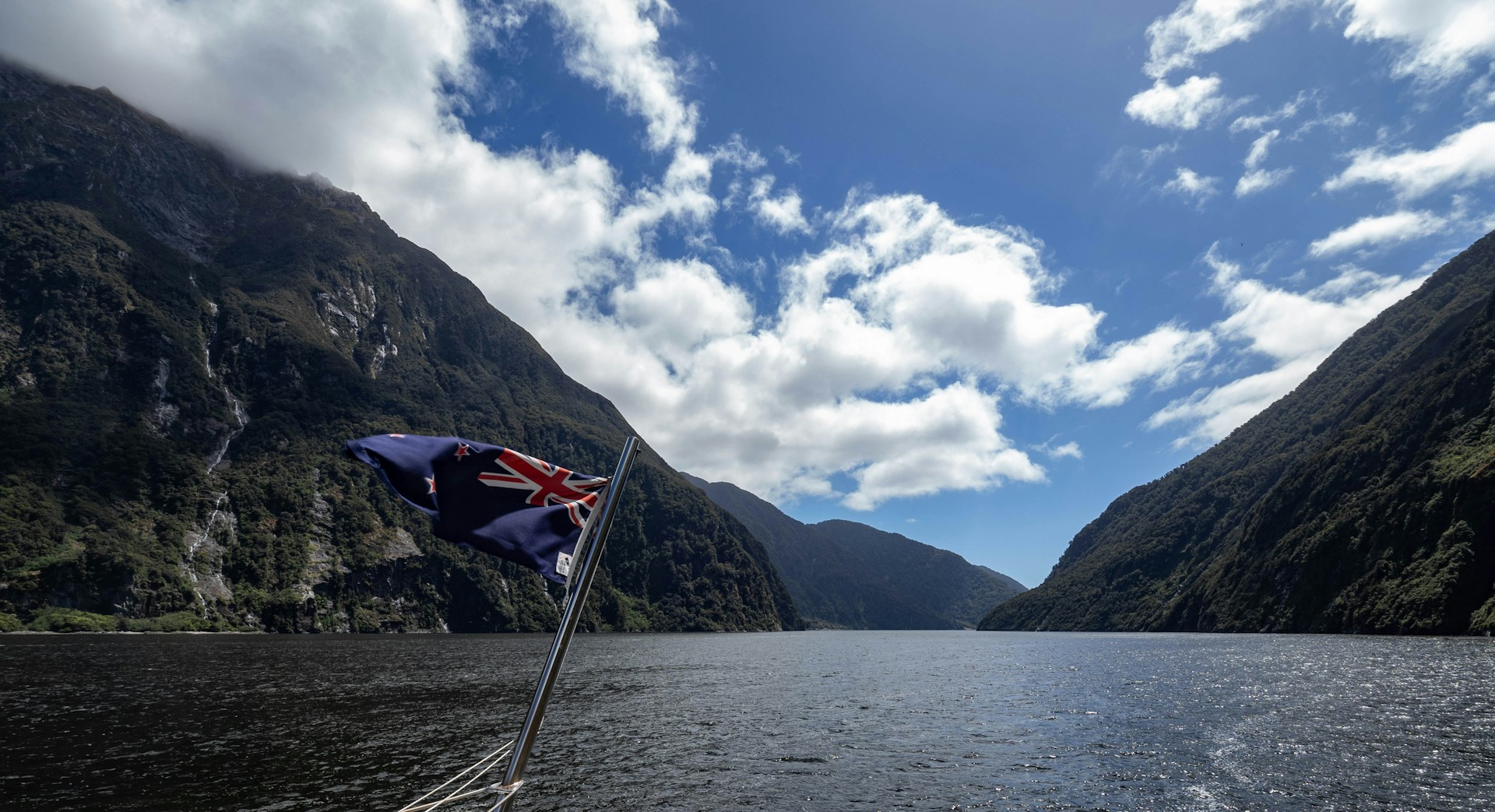 A boat traveling down a river surrounded by mountains