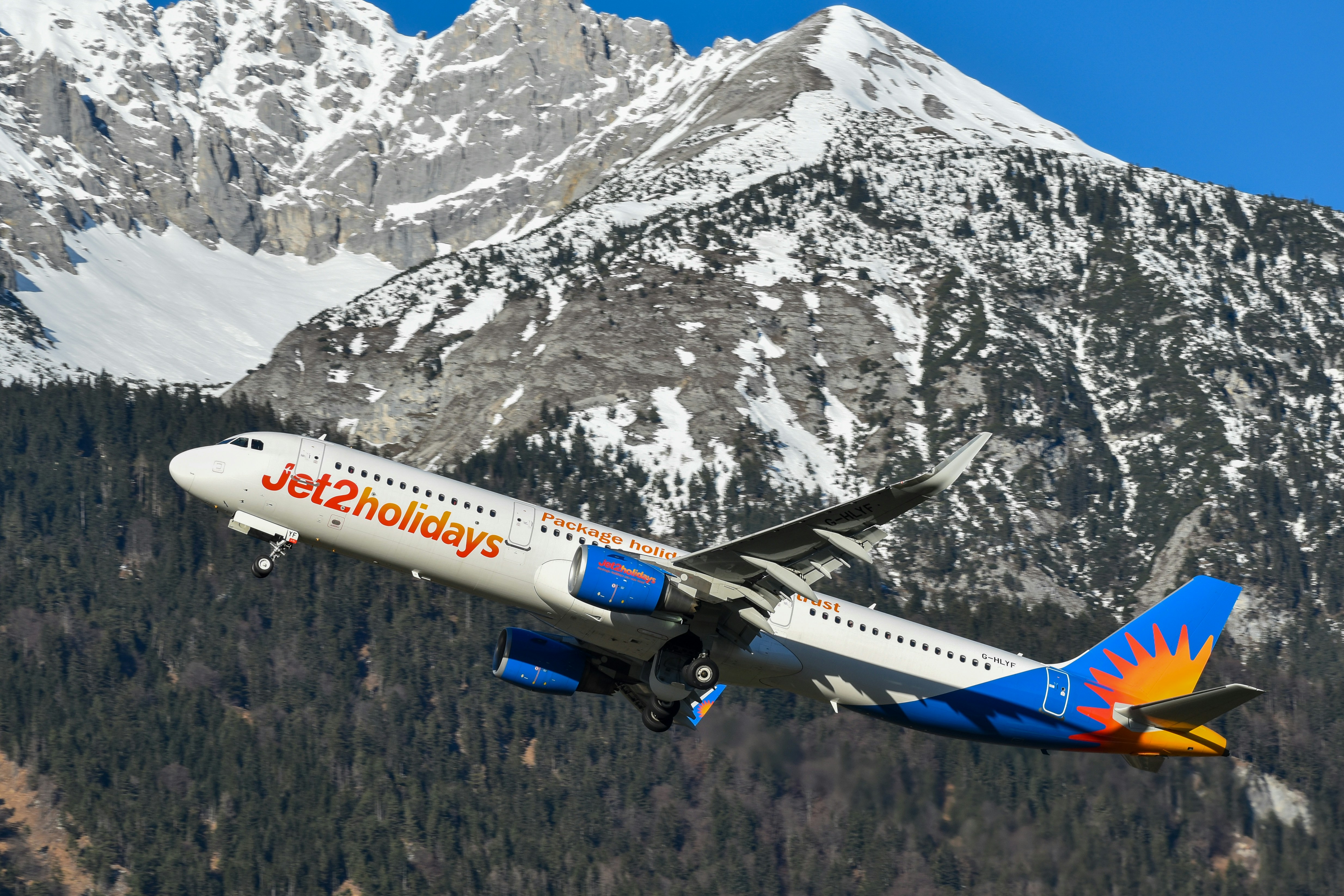 A Jet2Holiays jet flying with mountains in the background