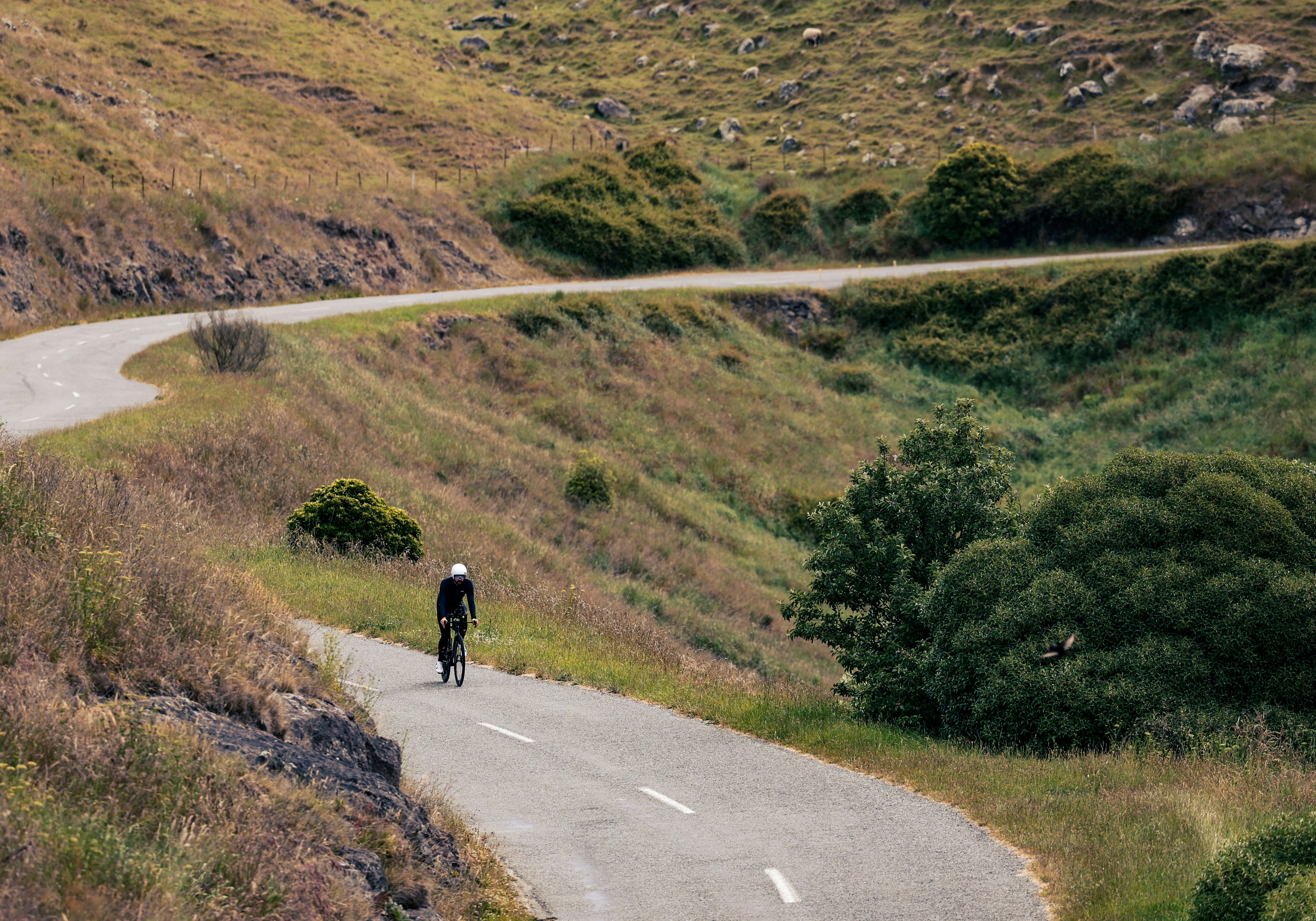 A man riding a bike down a winding road