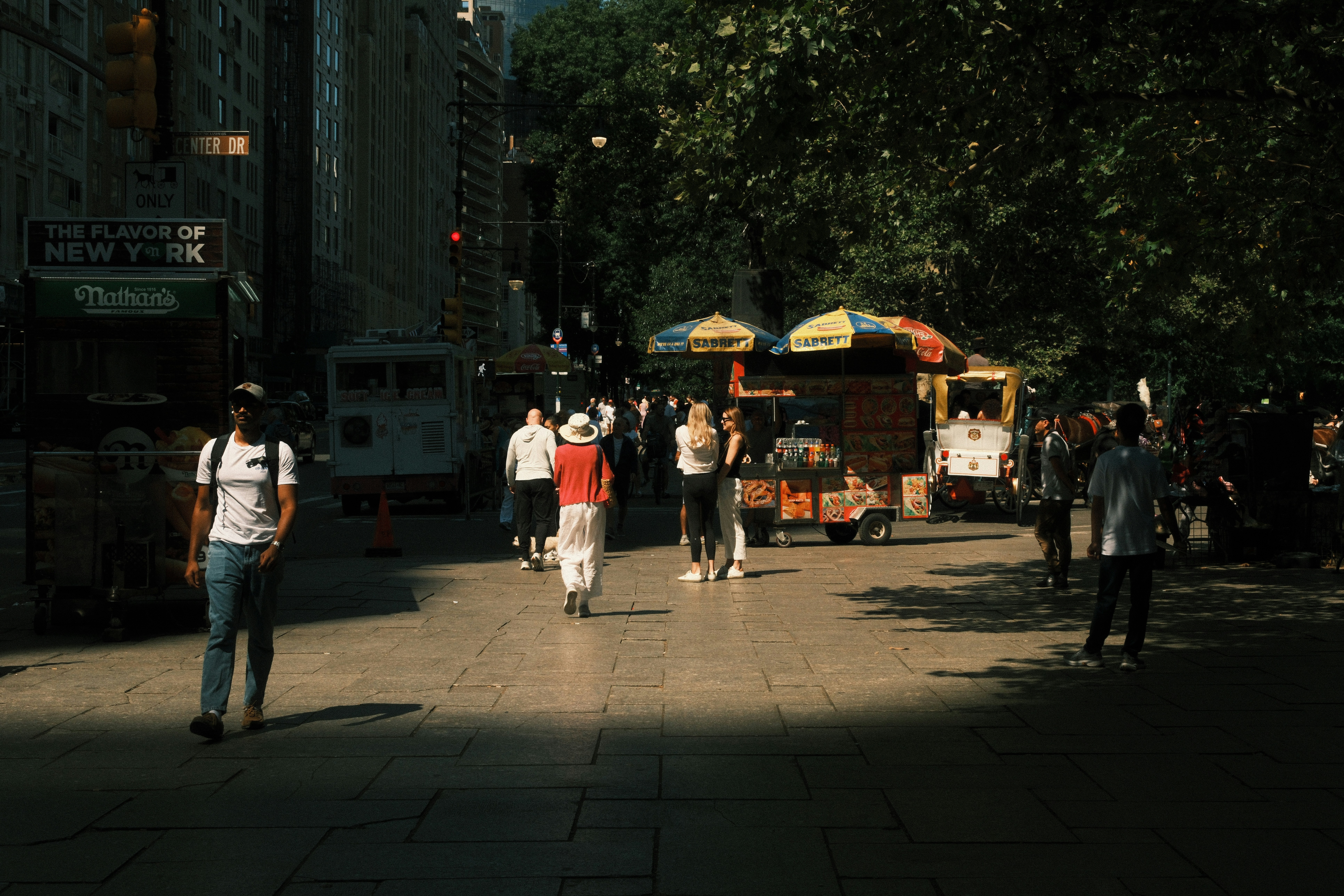 A group of people walking down a street next to tall buildings