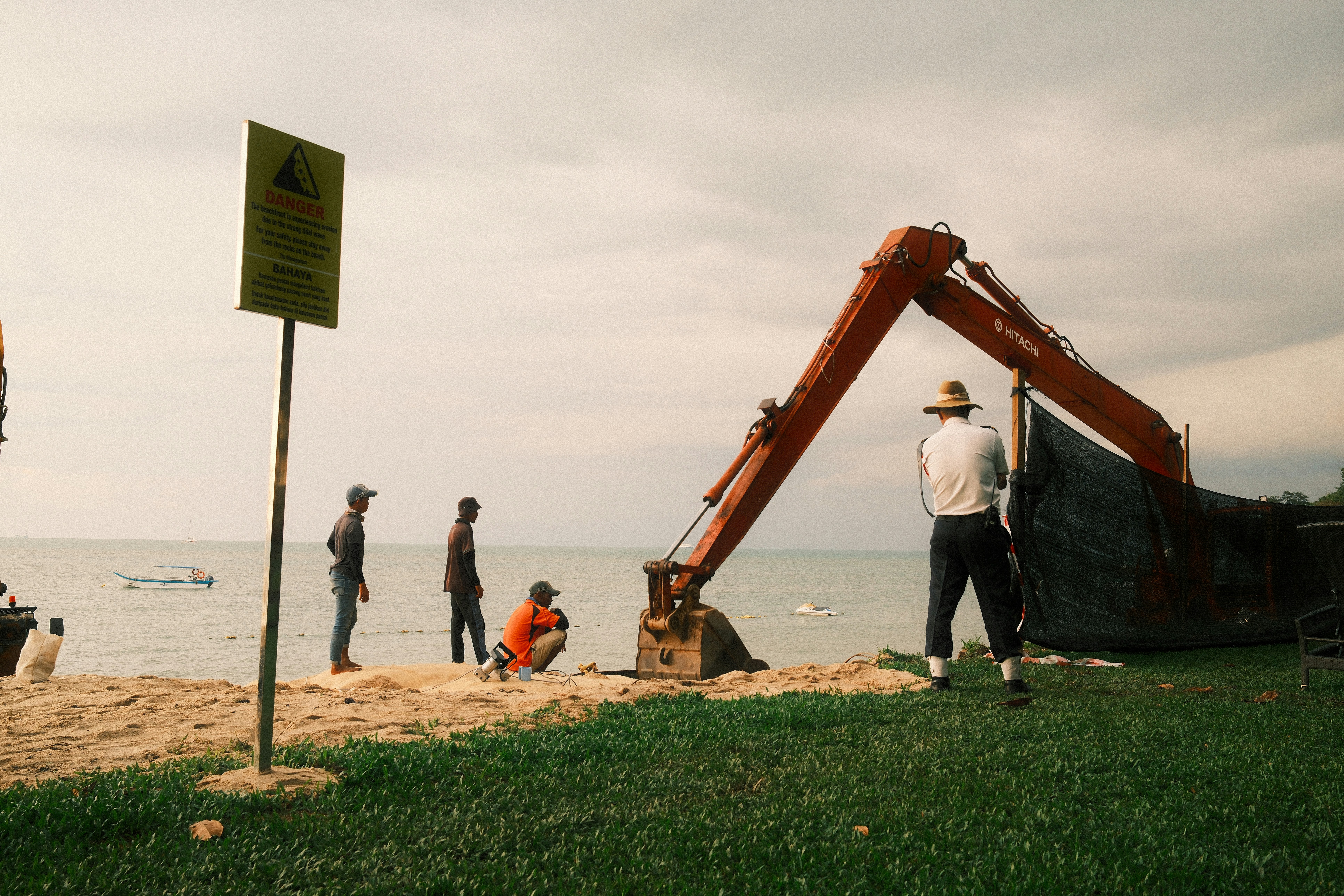 A group of people standing on top of a beach next to the ocean