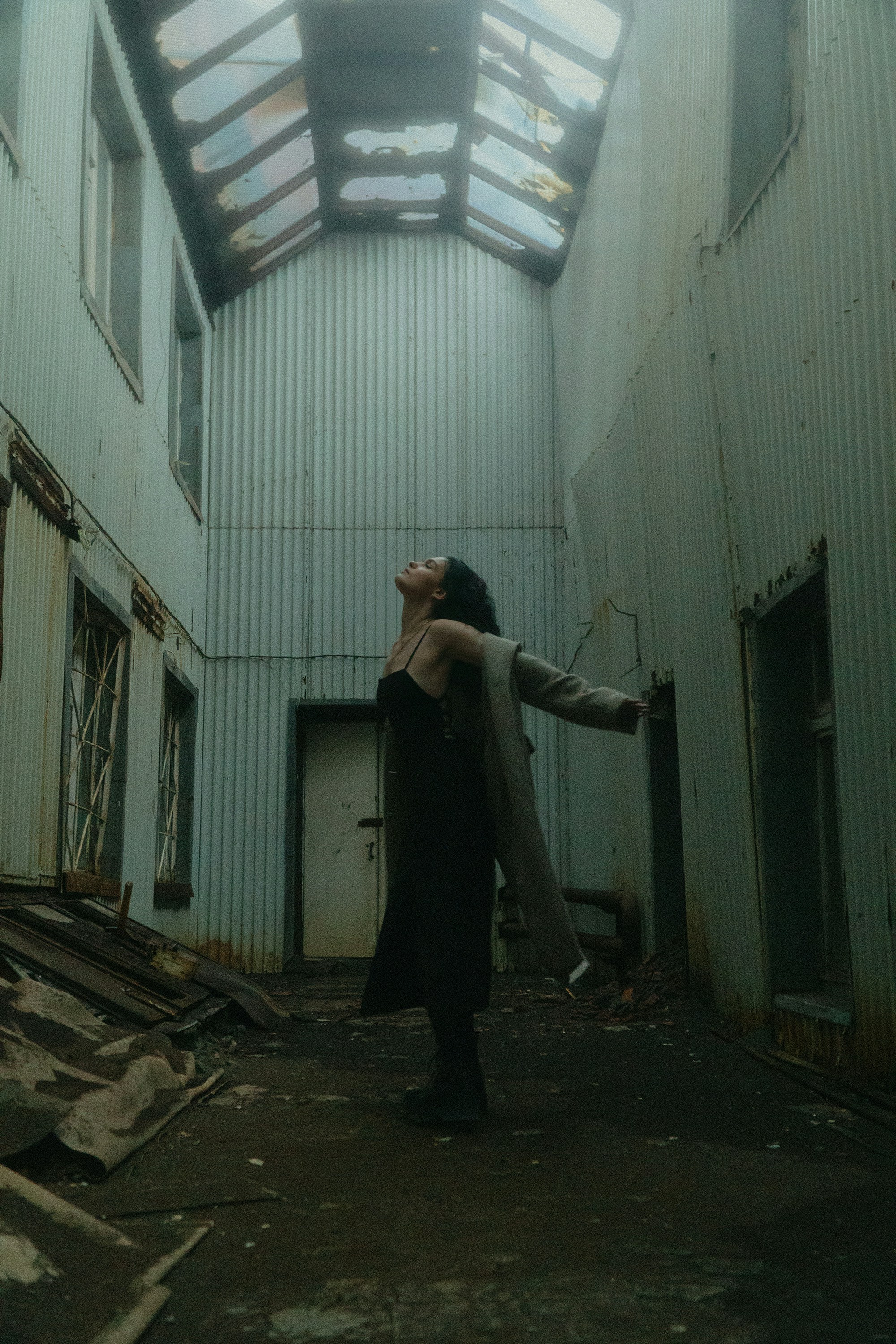 A woman is standing in an abandoned building