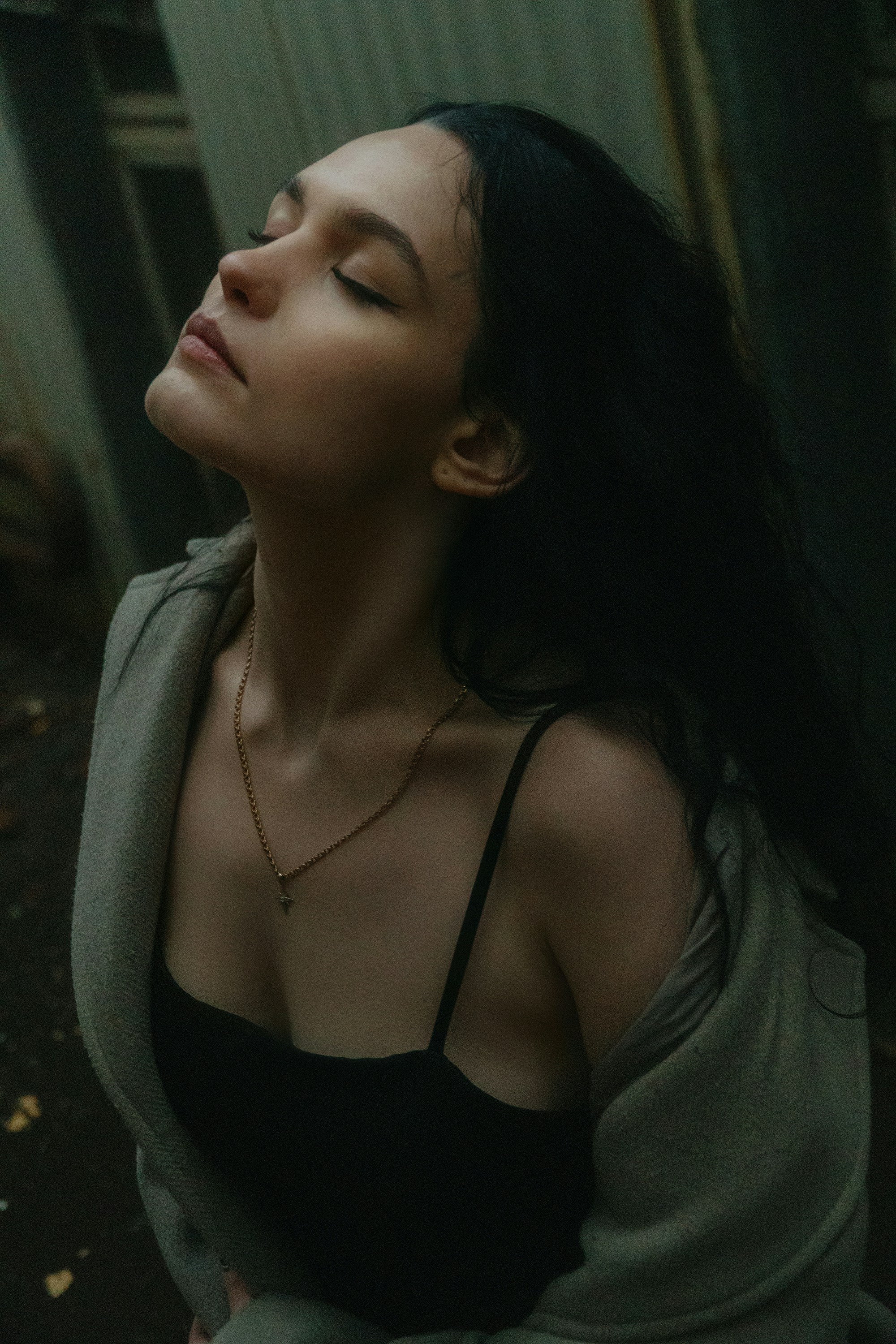 A woman with her eyes closed sitting on the ground