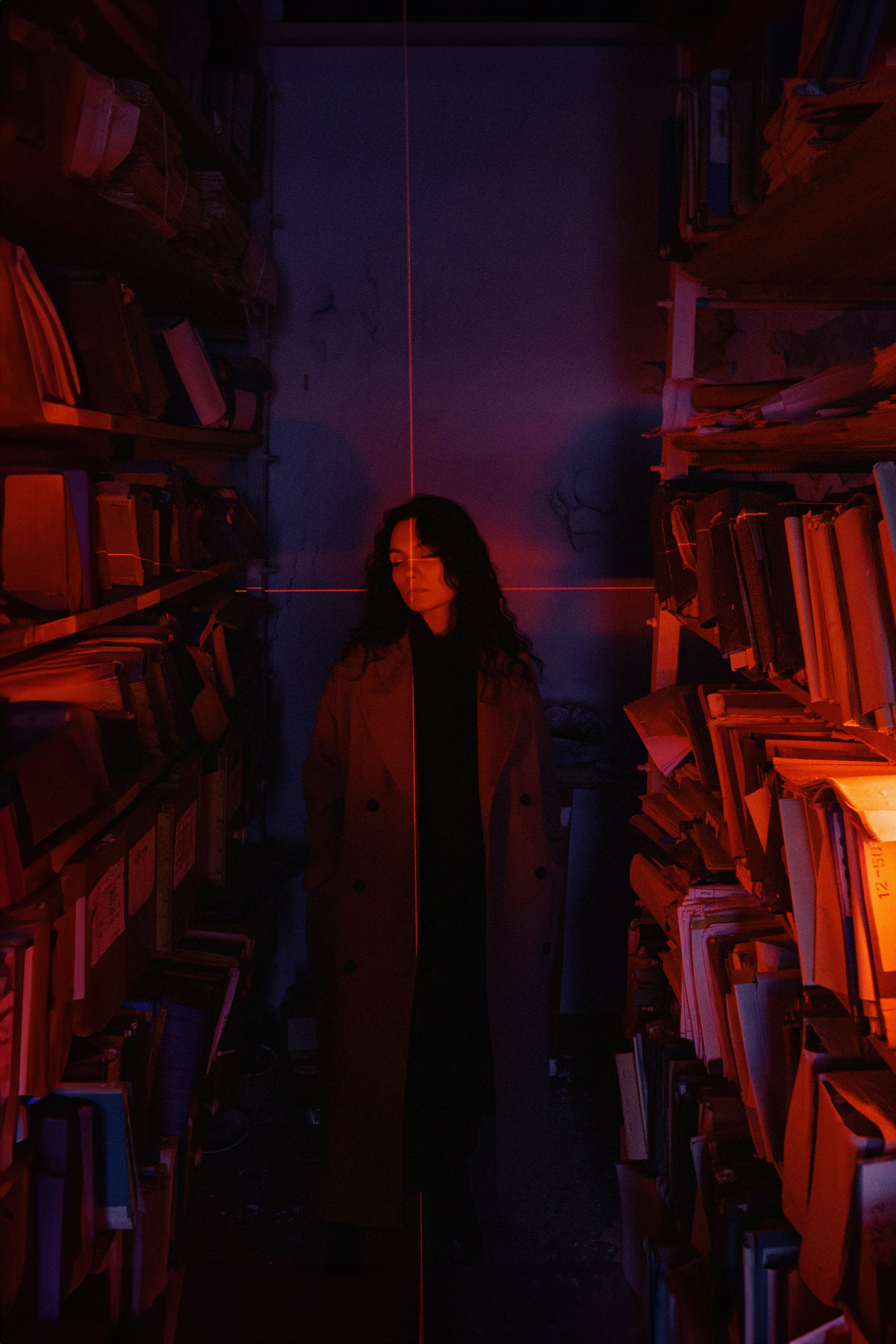 A woman standing in a room full of books