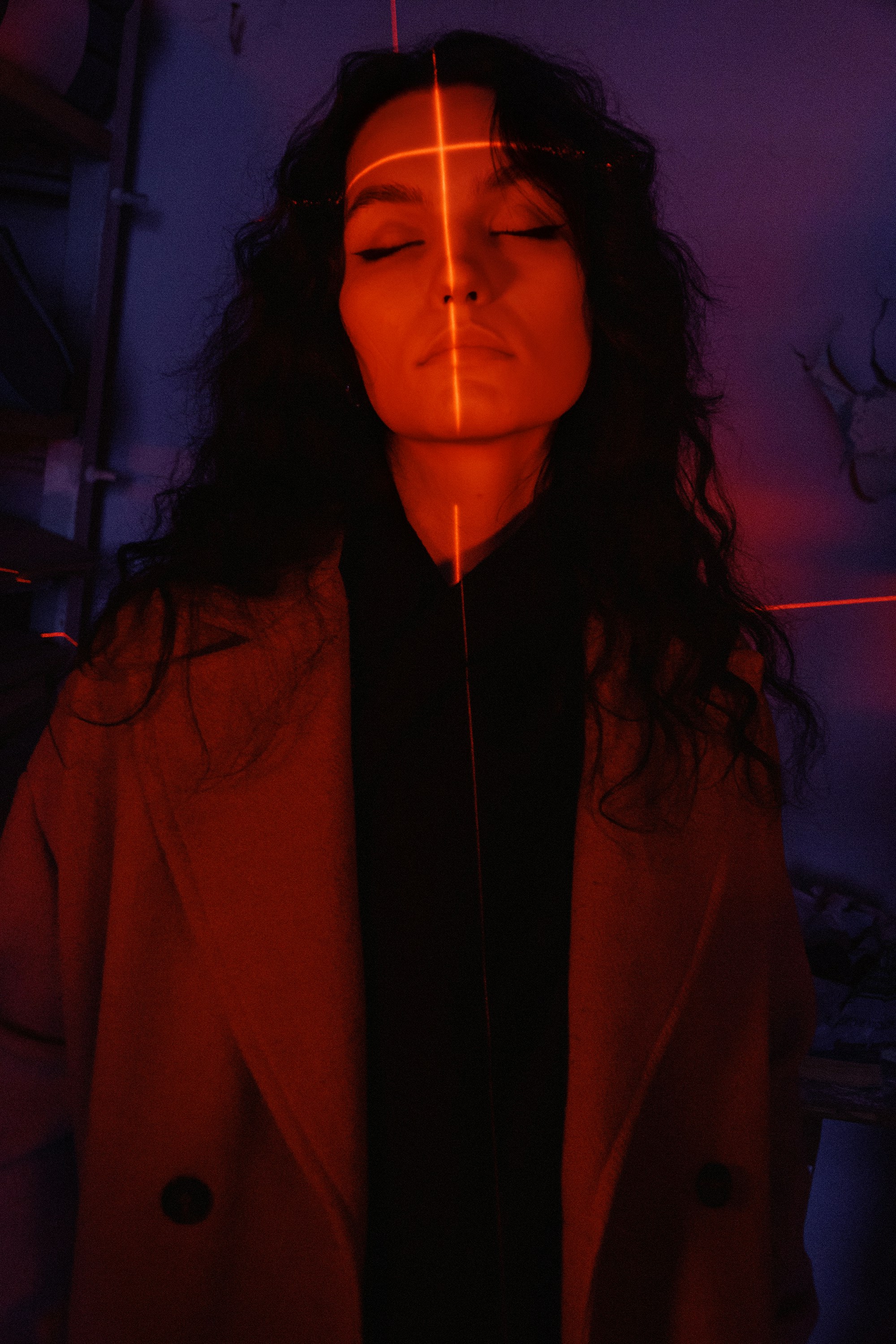 A woman standing in a room with a red light on her face