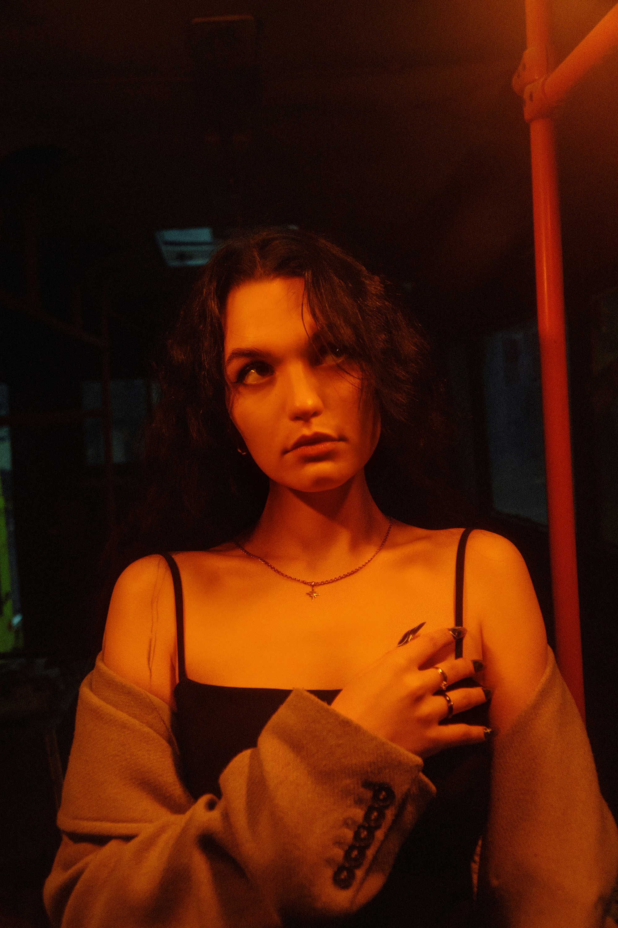 A woman standing in a dark room holding a cigarette