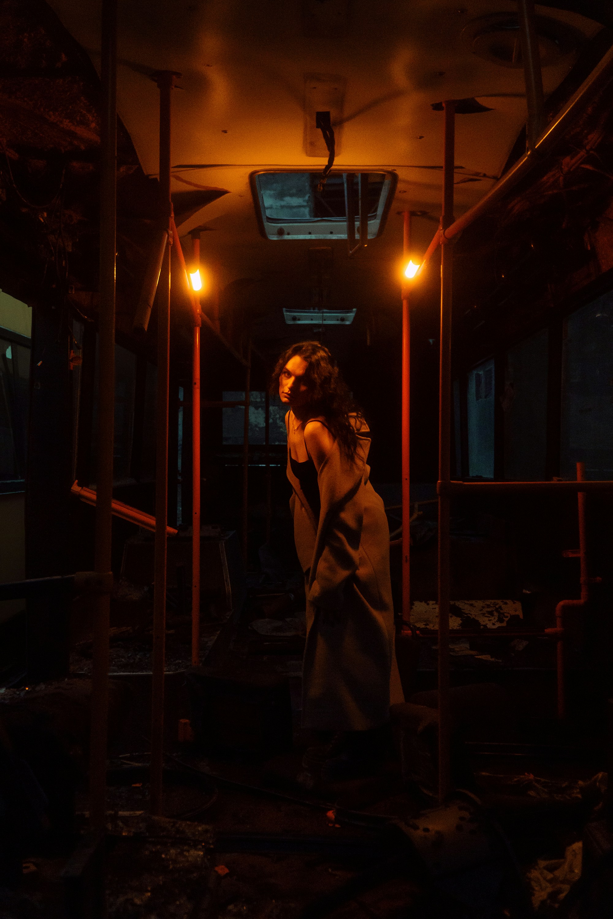 A woman standing in a train station at night