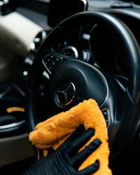 Car being buffed with a yellow microfibre cloth