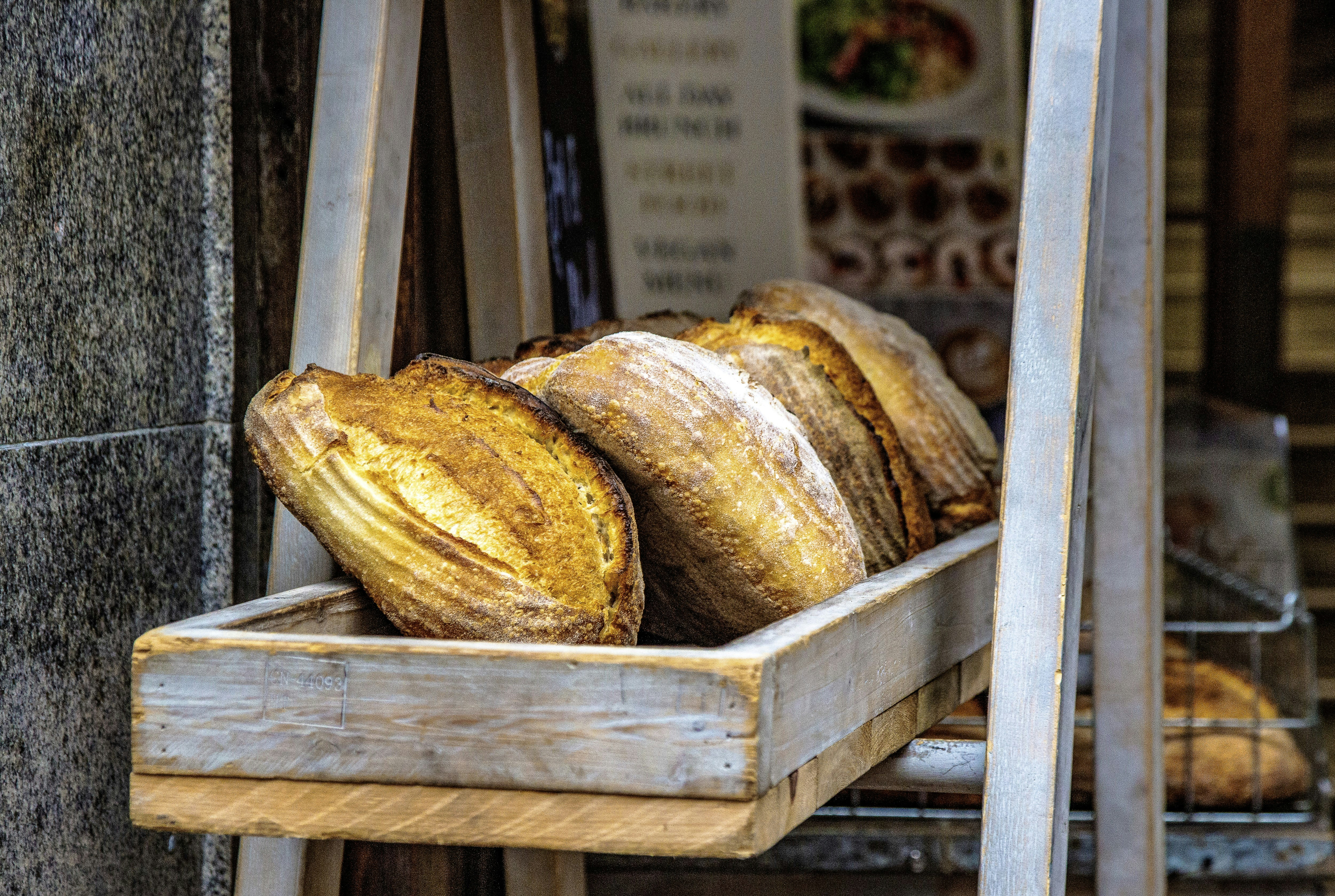 Artisanal bread loaves, cheese wheels, and gourmet preserves displayed on a rustic wooden table