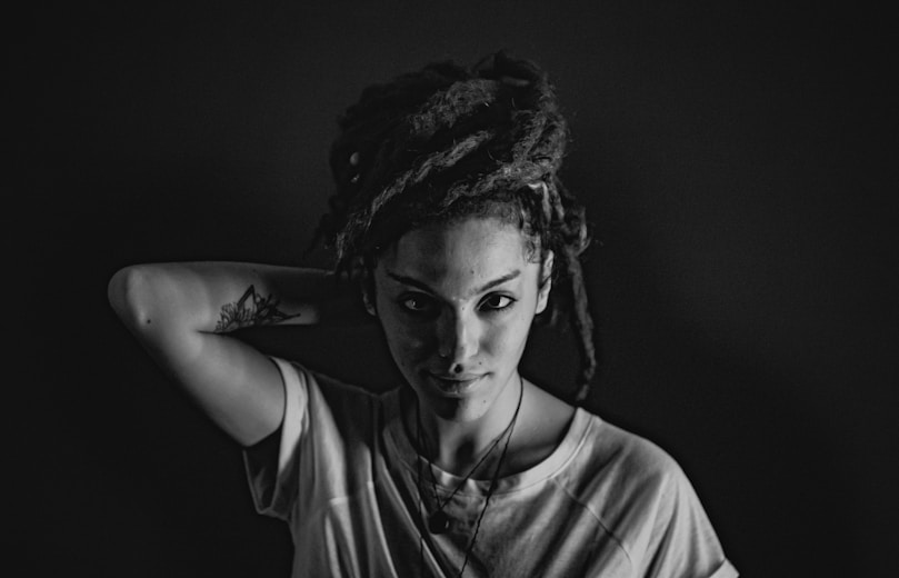 A black and white photo of a woman with dreadlocks
