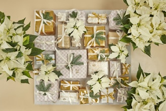 A table topped with lots of white flowers and wrapped presents