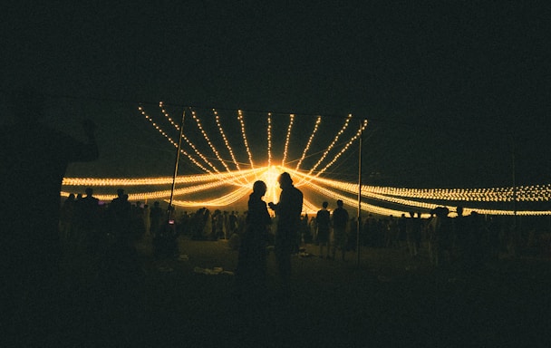 A group of people standing around a field at night