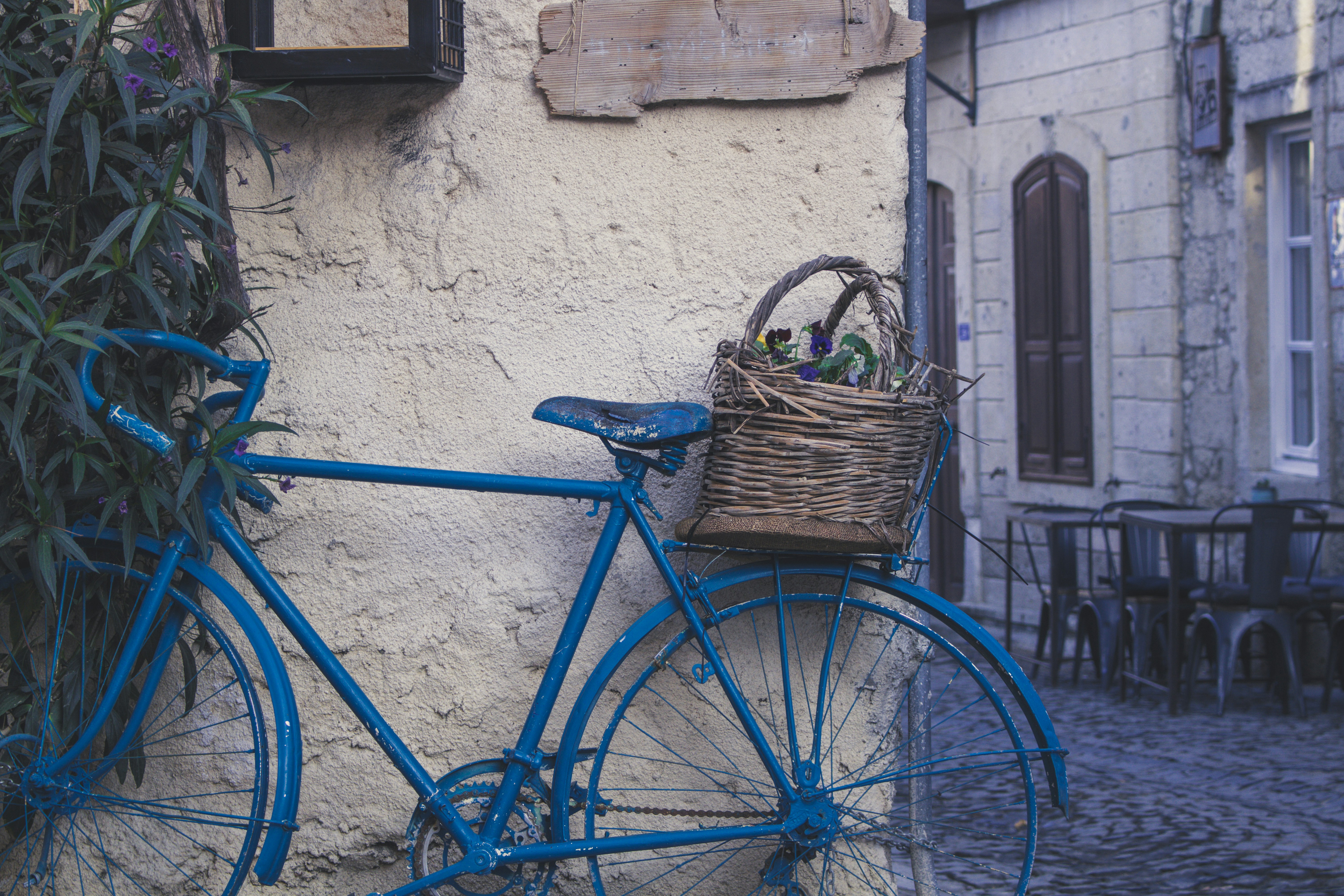 A blue bicycle parked next to a building