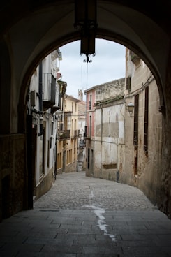 A narrow alley way with a clock on the wall