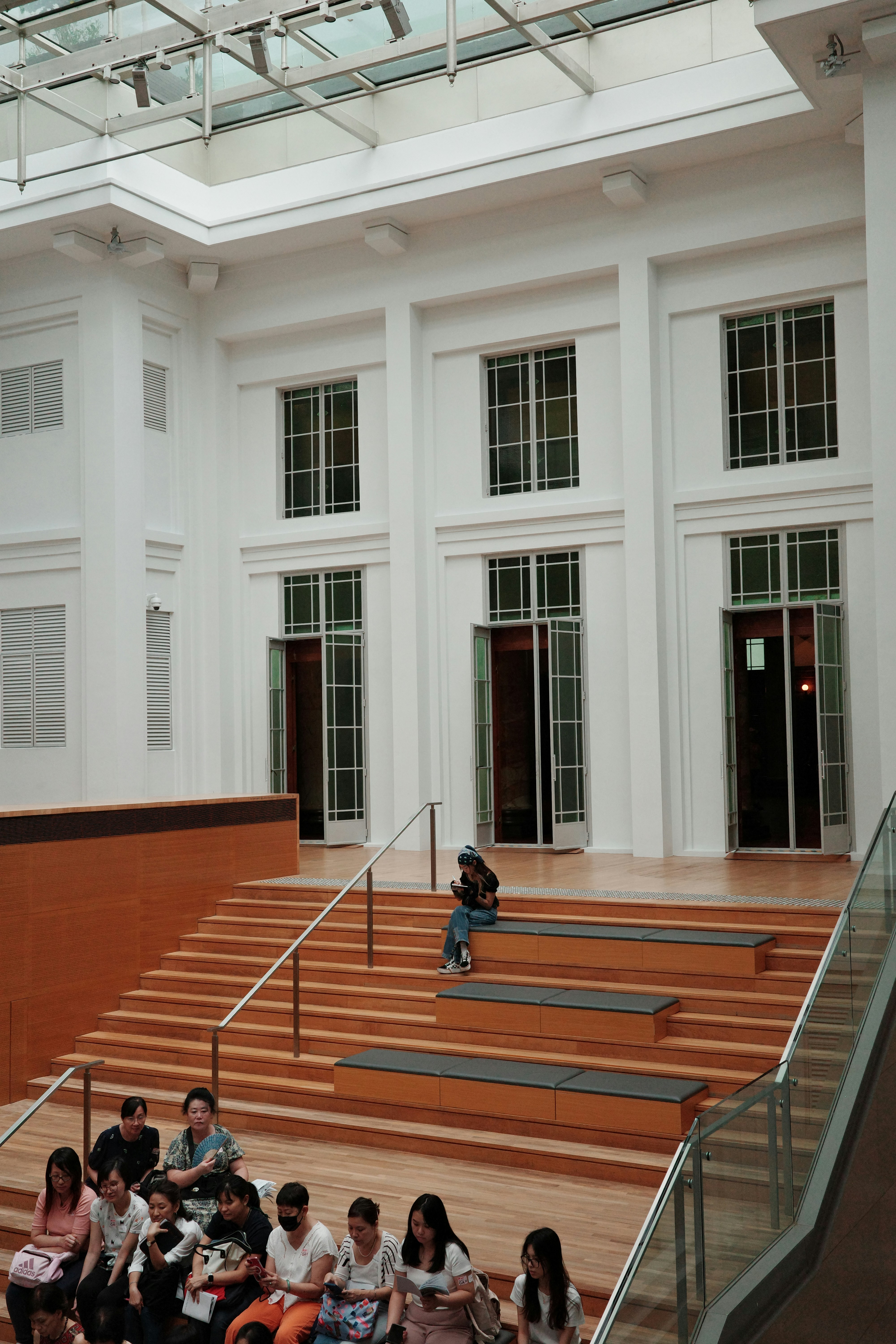 a girl sitting on the stairs of the museum and studying