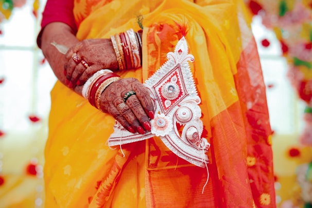 A close up of a woman wearing a yellow sari