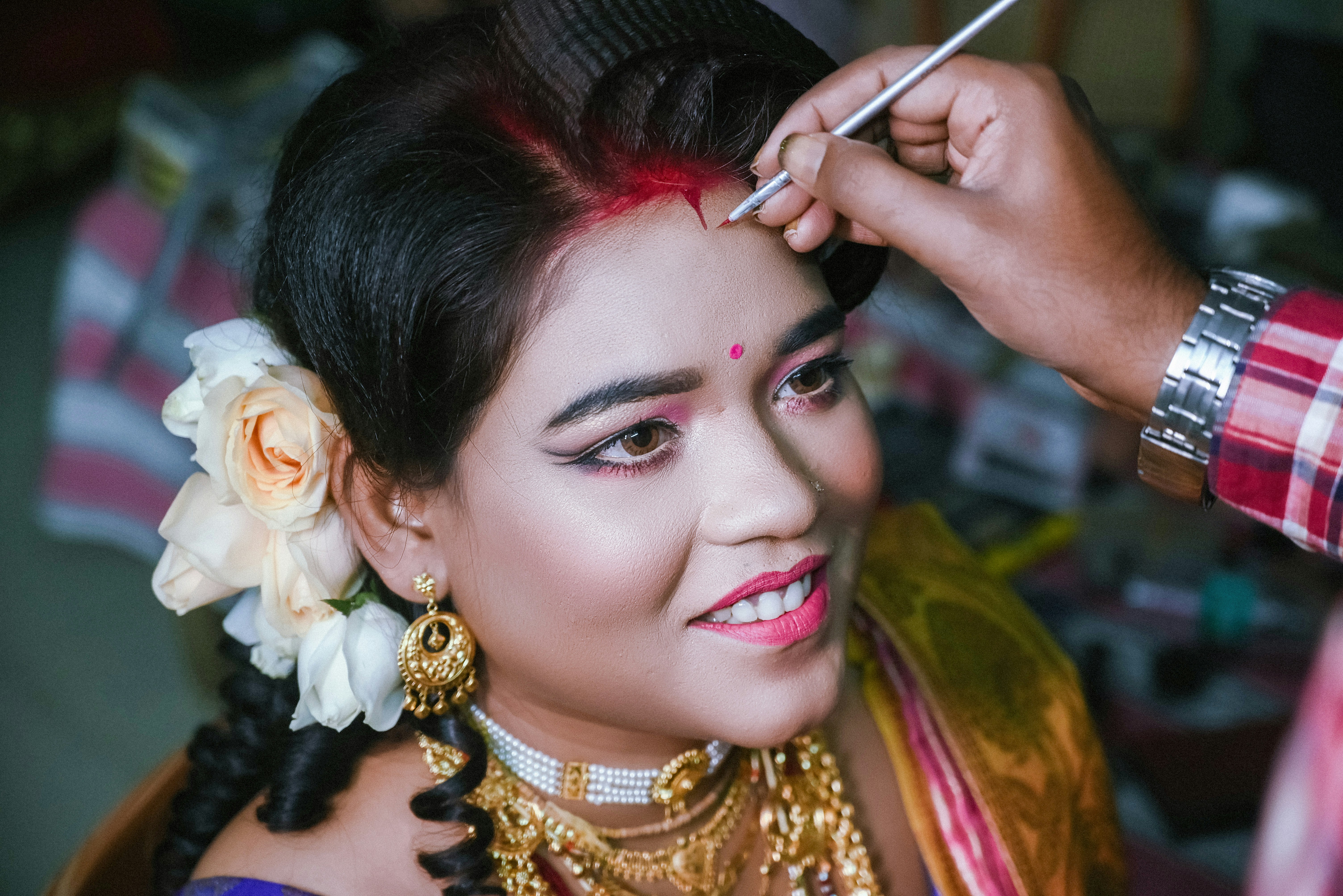 A woman getting her hair styled by a man