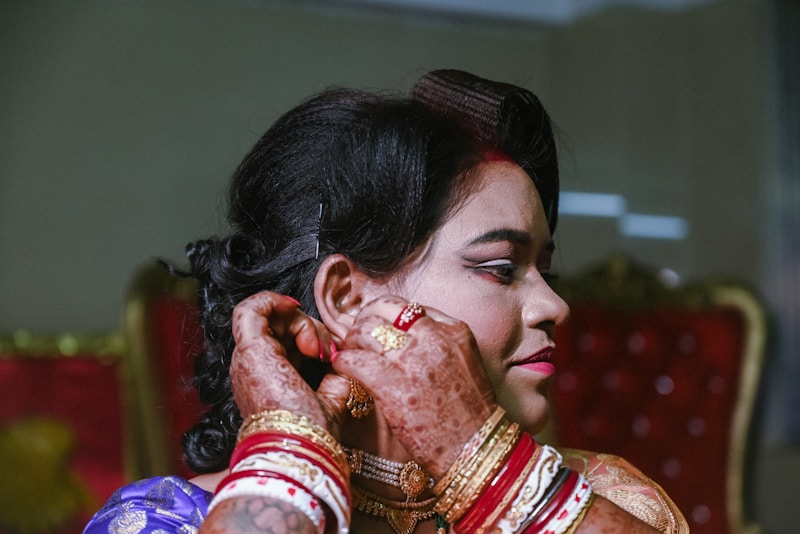 A woman in a sari putting on makeup
