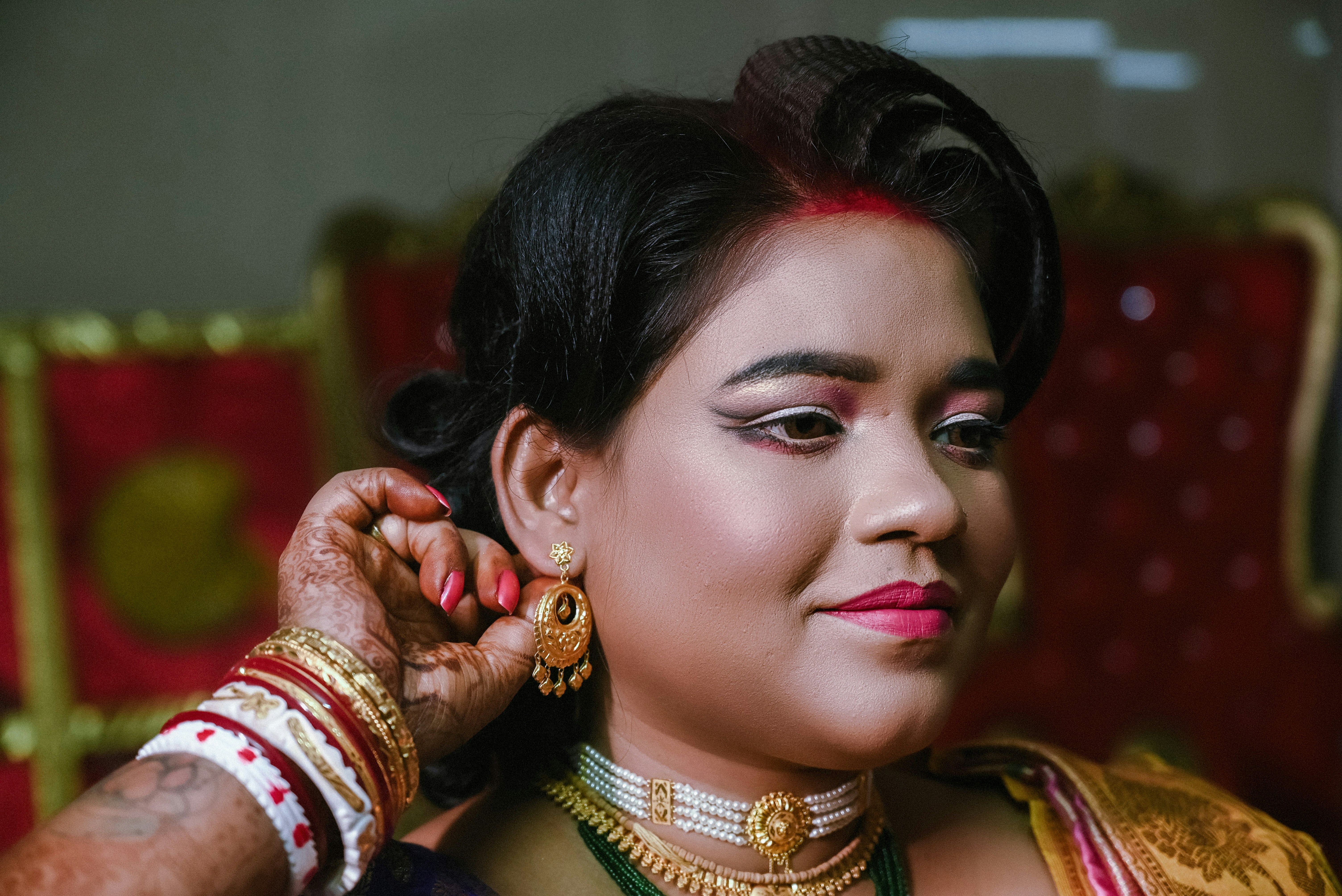 A woman in a sari putting on her jewelry