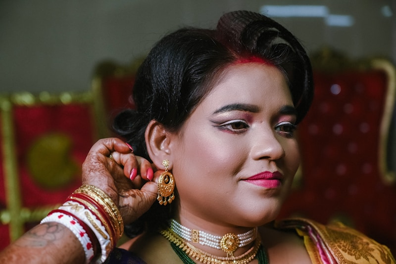 A woman in a sari putting on her jewelry