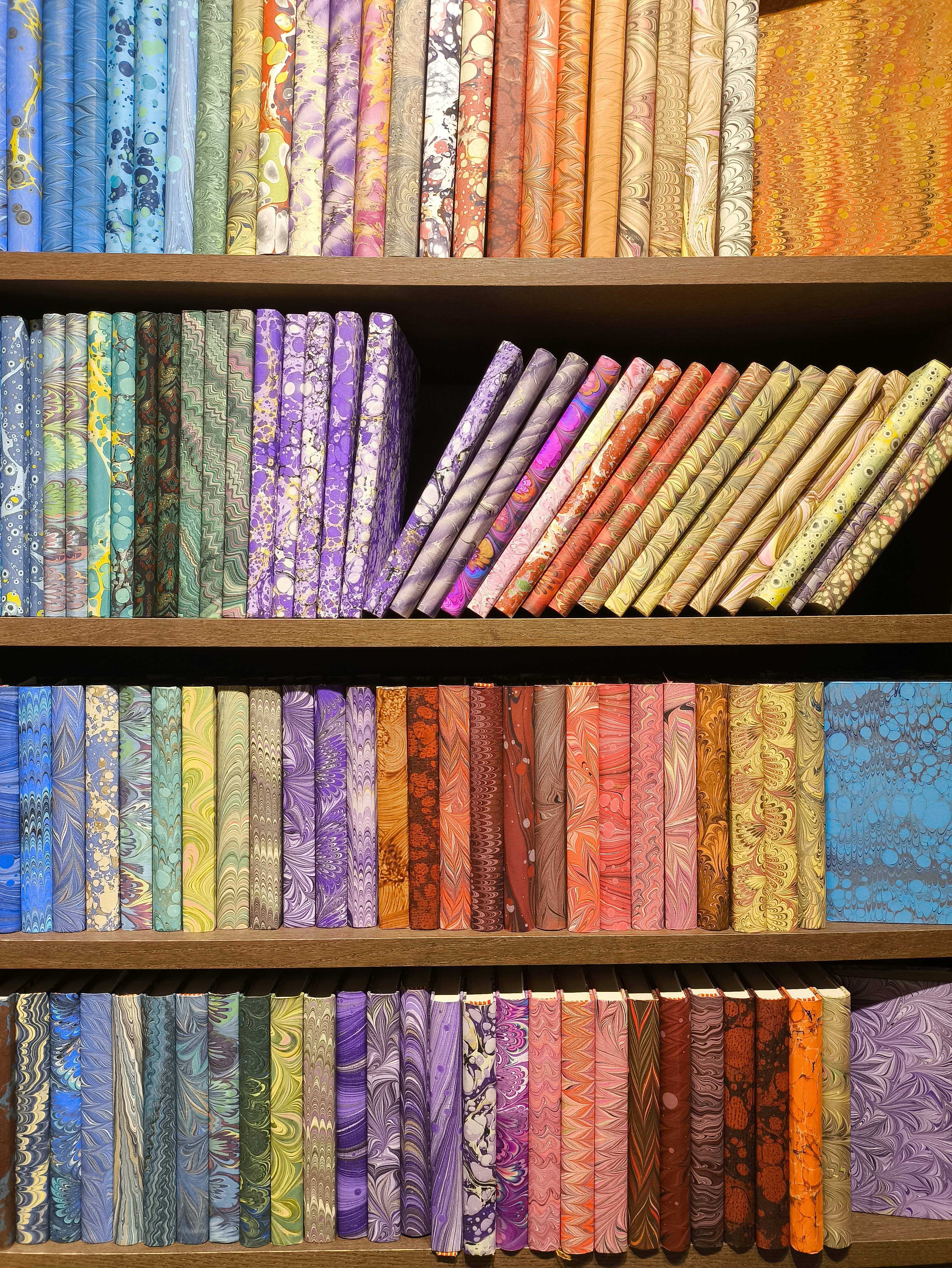 A book shelf filled with lots of different colored books