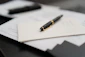A pen sitting on top of a pile of papers