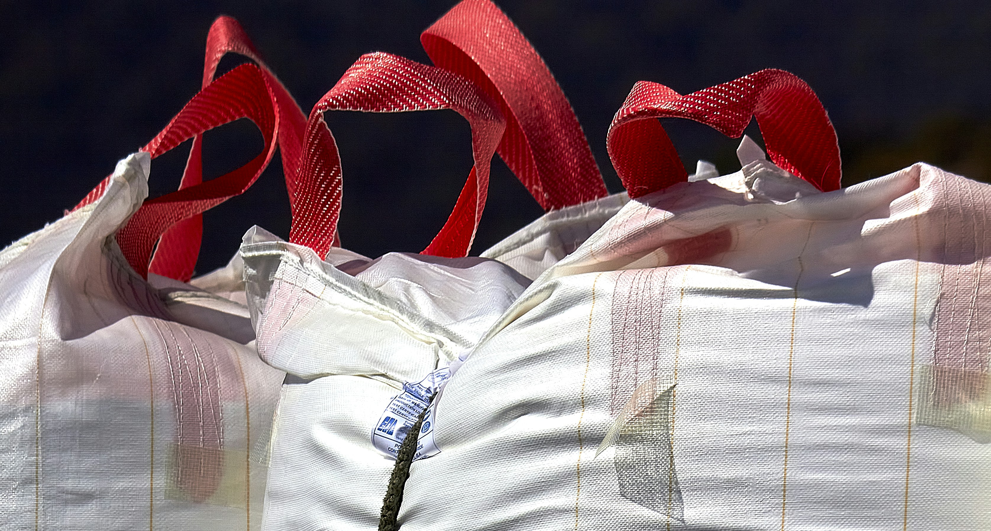 A row of bags with red ribbons on them