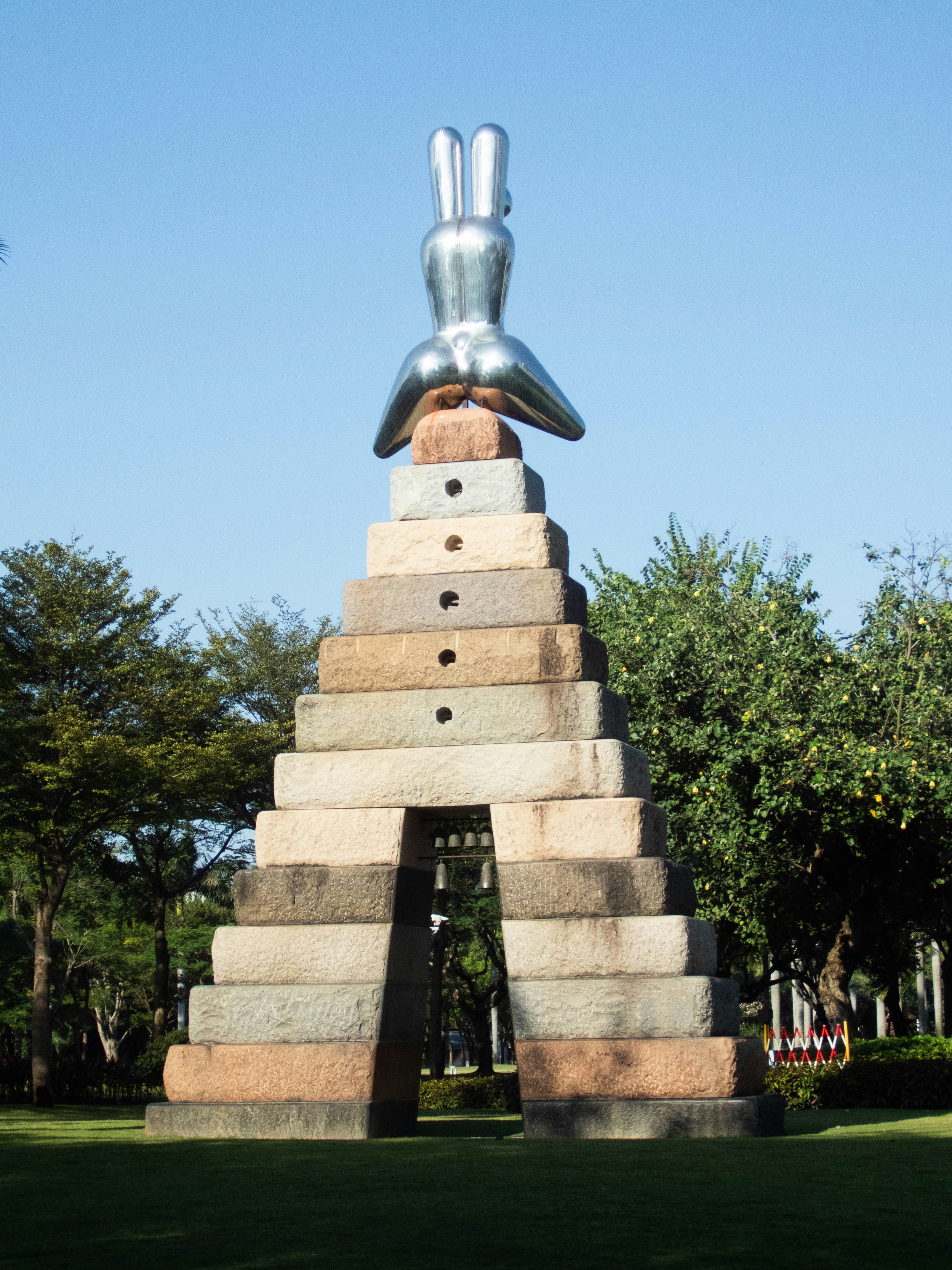 A large metal sculpture of a person's legs sticking out of the top of